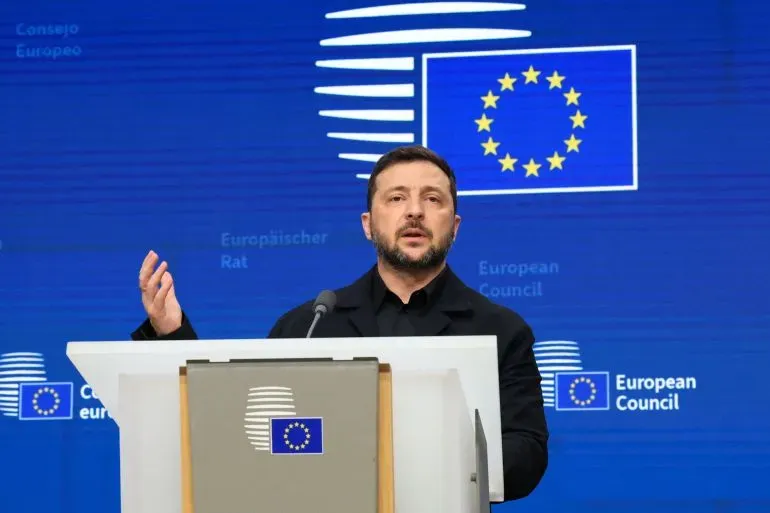 الرئيس الأوكراني فولوديمير زيلينسكي يتحدث خلال قمة الاتحاد الأوروبي في بروكسل، مع خلفية شعار الاتحاد الأوروبي.
