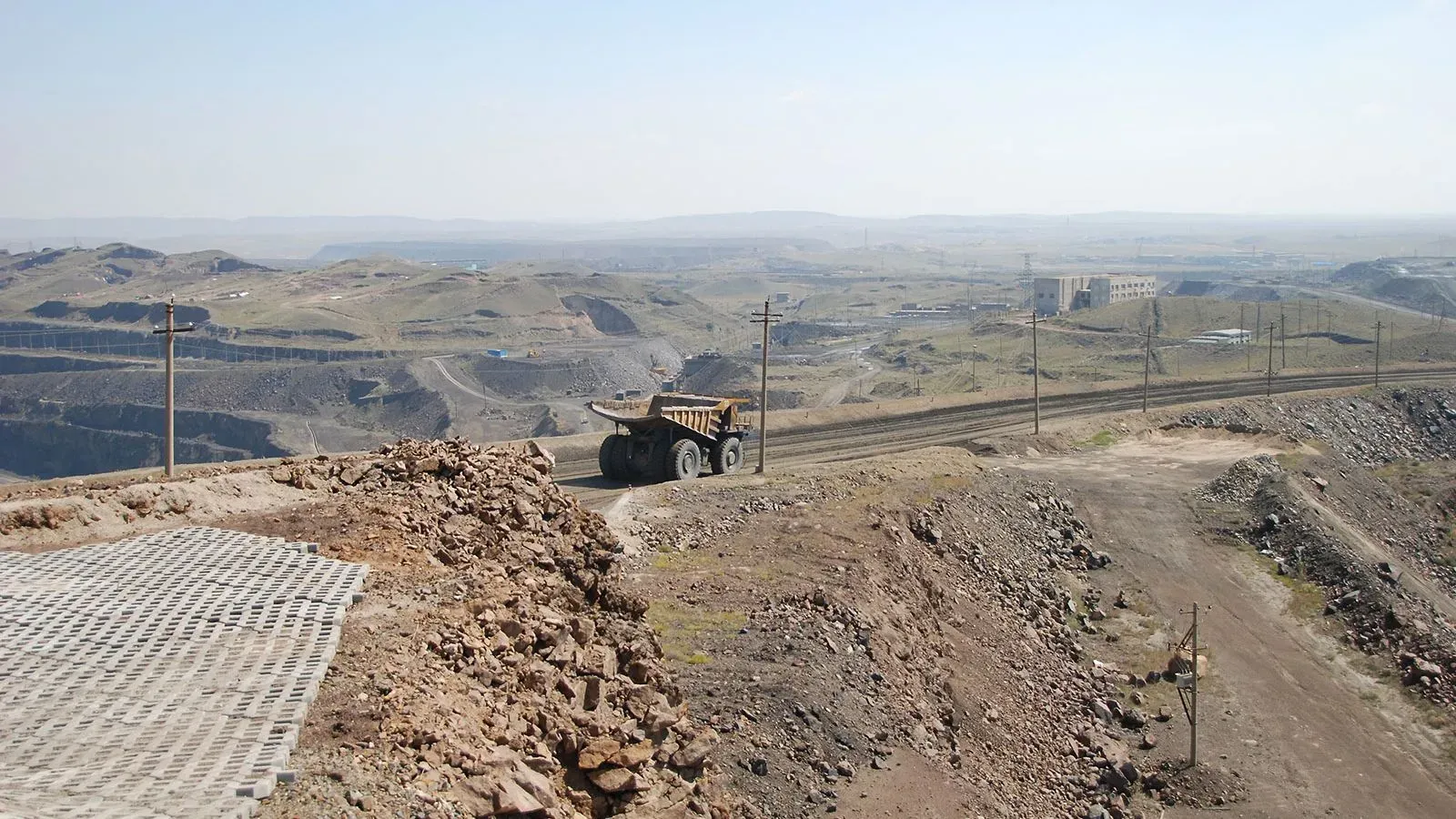 منطقة شاسعة من الأرض مع شاحنة كبيرة تعمل في منجم للمعادن الأرضية النادرة، تعكس أهمية هذه الموارد للصناعات العالمية.