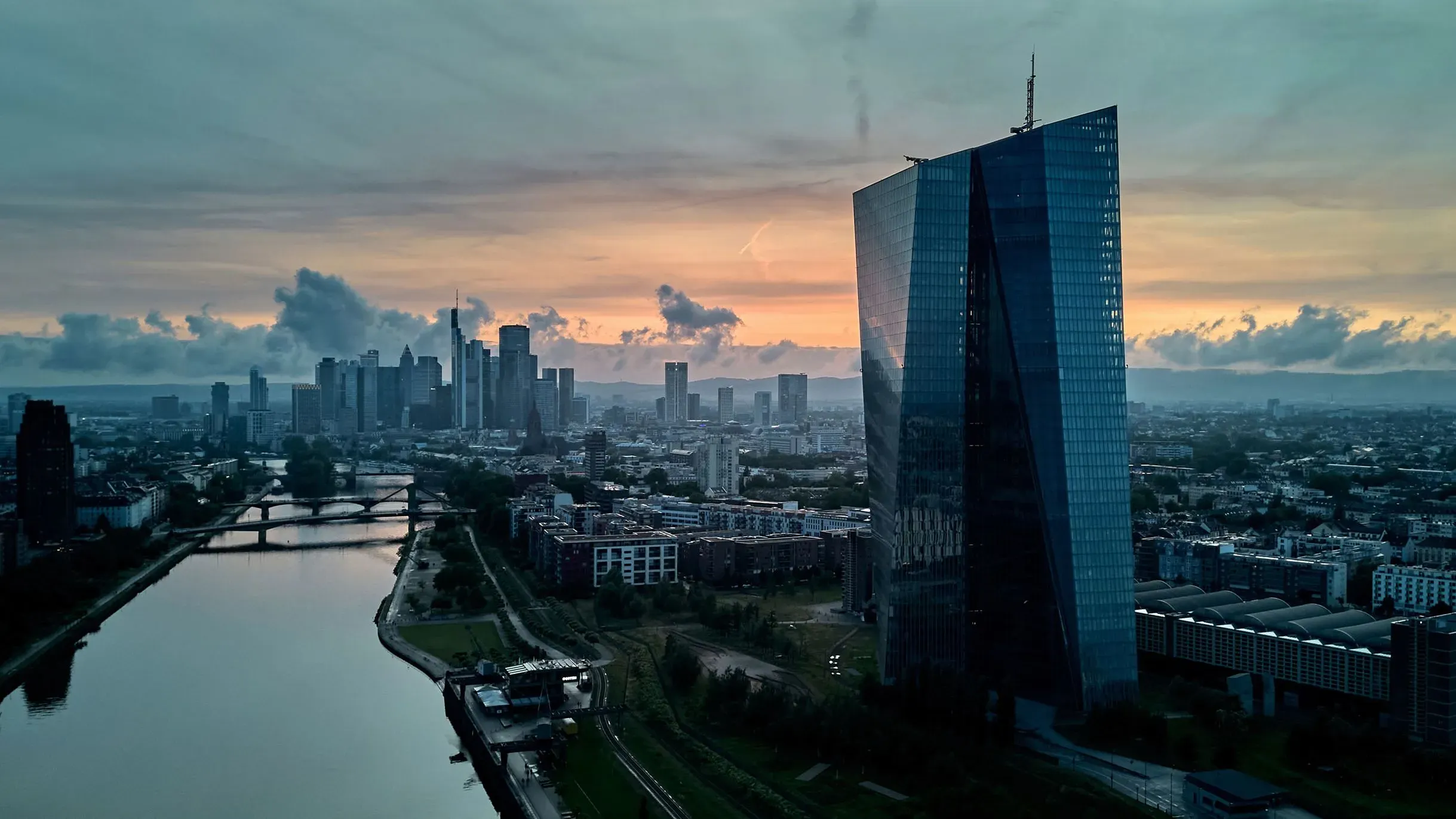 مبنى البنك المركزي الأوروبي في فرانكفورت مع أفق المدينة في الخلفية، يعكس تأثير السياسة النقدية على الاقتصاد الأوروبي.