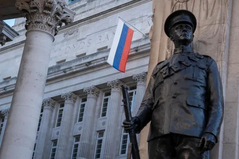 تمثال لجندي روسي يقف أمام مبنى حكومي، مع العلم الروسي يرفرف في الخلفية، مما يعكس التوترات الجيوسياسية الحالية.