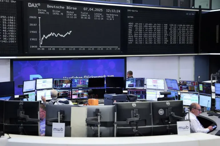 تظهر الصورة غرفة تداول بأسواق الأسهم الأوروبية، مع التركيز على شاشة تعرض بيانات مؤشر داكس الألماني وتفاصيل السوق.