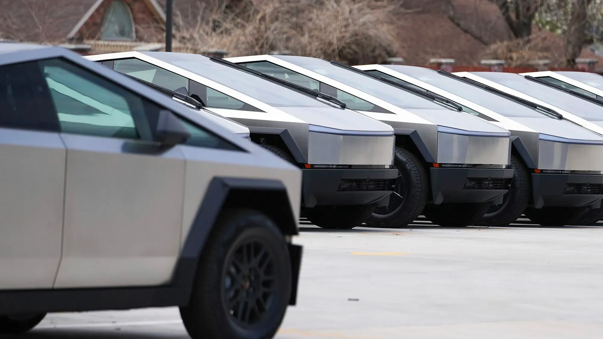 صف من سيارات تسلا الكهربائية ذات التصميم الفريد، تُظهر التحديات التي تواجهها الشركة في ظل التوترات السياسية والاقتصادية.