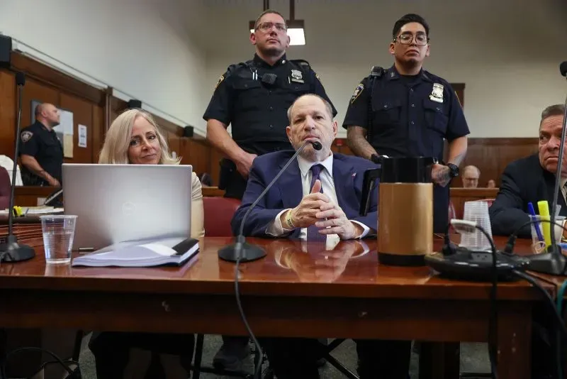 هارفي واينستين يجلس في قاعة المحكمة محاطًا بمحاميه ورجال الشرطة، بينما تستمر محاكمته بتهم الاعتداء الجنسي.