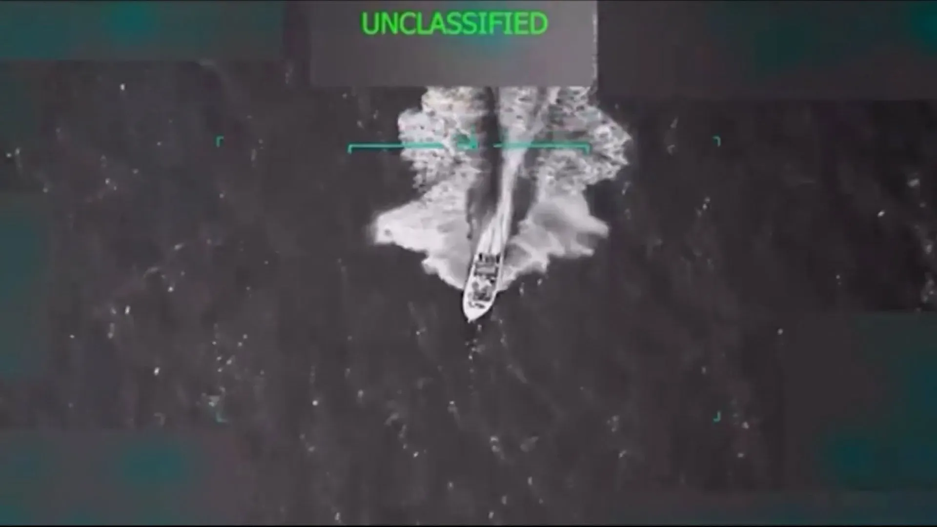 قارب سريع يبحر في المياه، يظهر من خلال لقطات جوية، مرتبط بعملية عسكرية أمريكية ضد تهريب المخدرات في منطقة البحر الكاريبي.