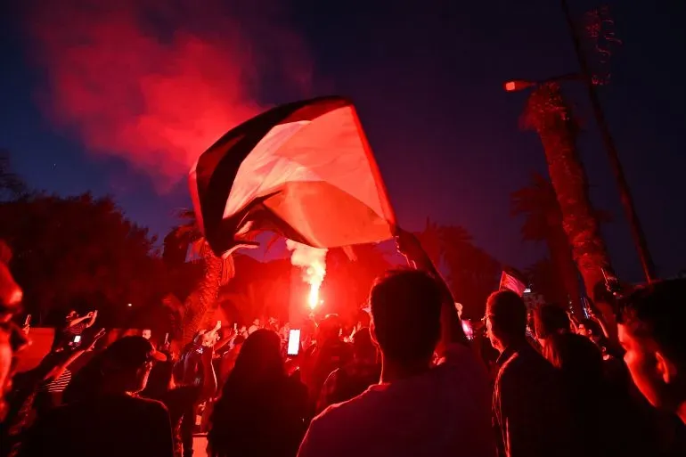 محتجون يحملون الأعلام الفلسطينية ويضيئون الشموع في مسيرة لرفع الوعي حول الأوضاع في غزة، وسط أجواء من الحماس والتضامن.