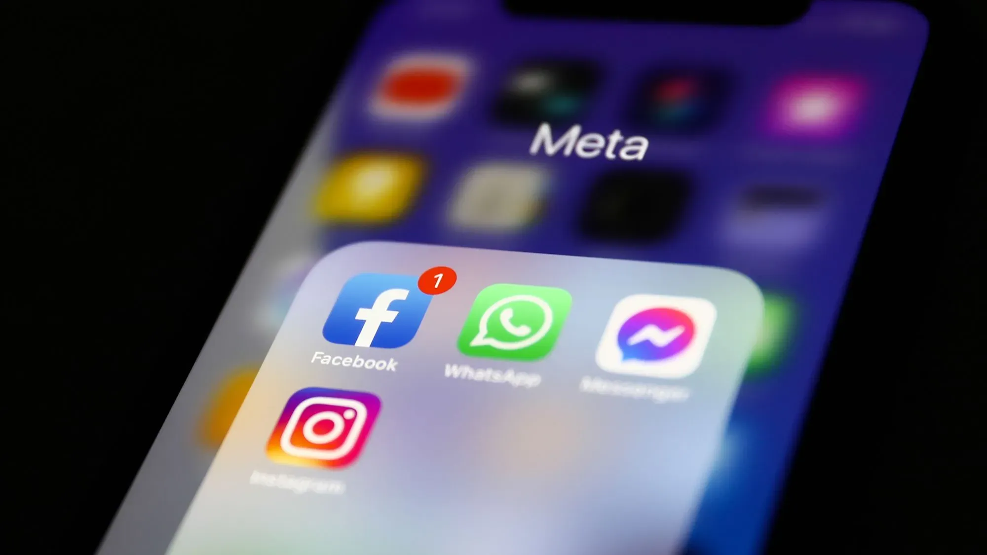 تطبيق Meta يظهر على شاشة هاتف ذكي، مع أيقونات فيسبوك وواتساب وإنستغرام، مما يعكس جهود الشركة في الذكاء الاصطناعي والتكنولوجيا الحديثة.