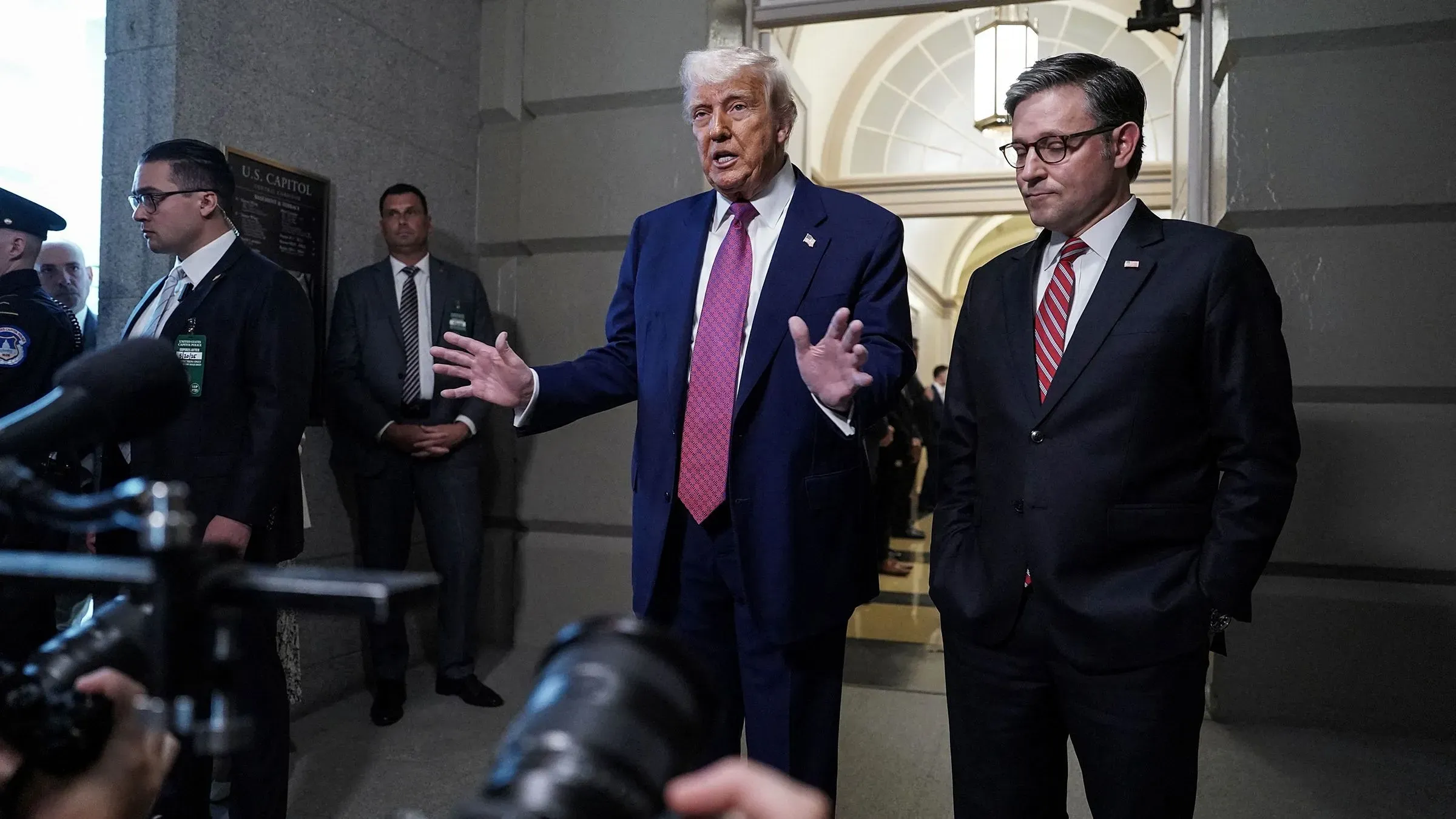 ترامب يتحدث للصحفيين حول برنامج Medicaid في مبنى الكابيتول، مع وجود مستشارين وموظفين أمنيين خلفه.