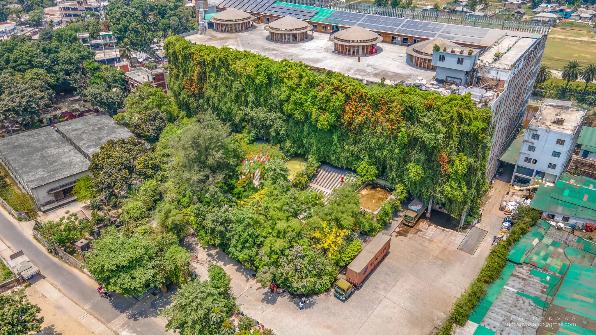 مصنع Green Field في بنغلاديش مغطى بجدار نباتي وحدائق داخلية، يعكس تصميمًا مستدامًا يدمج الطبيعة لتحسين بيئة العمل.