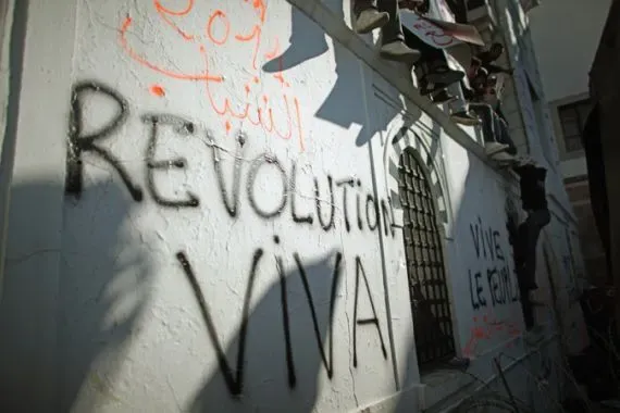 جدارية تحمل شعارات "ثورة" و"عاش" باللغتين الفرنسية والعربية، تعكس أصداء الثورة التونسية وتطلعات الشعب نحو التغيير.