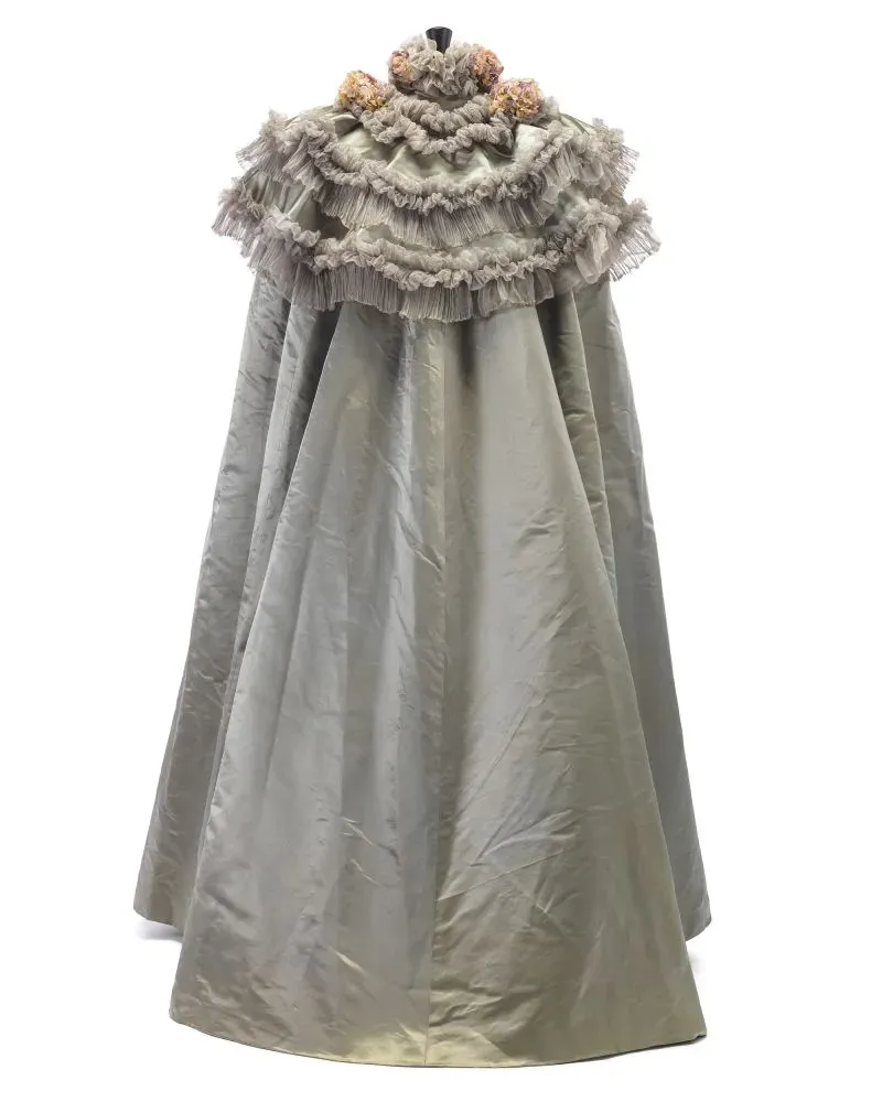 فستان أنيق بتصميم فريد من الأقمشة الفاخرة، يظهر تفاصيل من الدانتيل والتجاعيد، يعكس إرث تشارلز فريدريك وورث في عالم الأزياء الراقية.