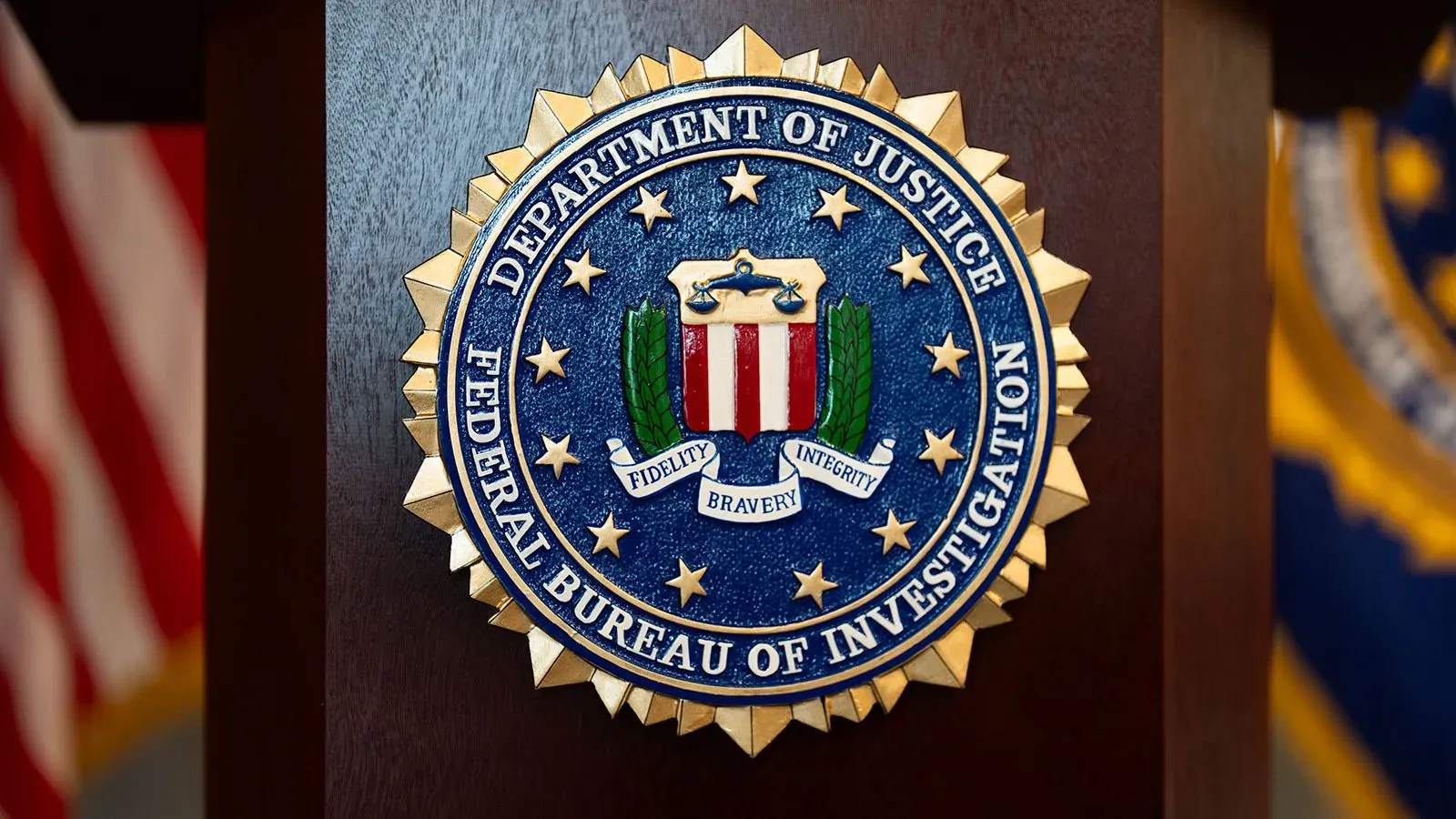 شعار مكتب التحقيقات الفيدرالي (FBI) مع خلفية رمادية، يرمز إلى الأمانة والنزاهة والشجاعة في التحقيقات.