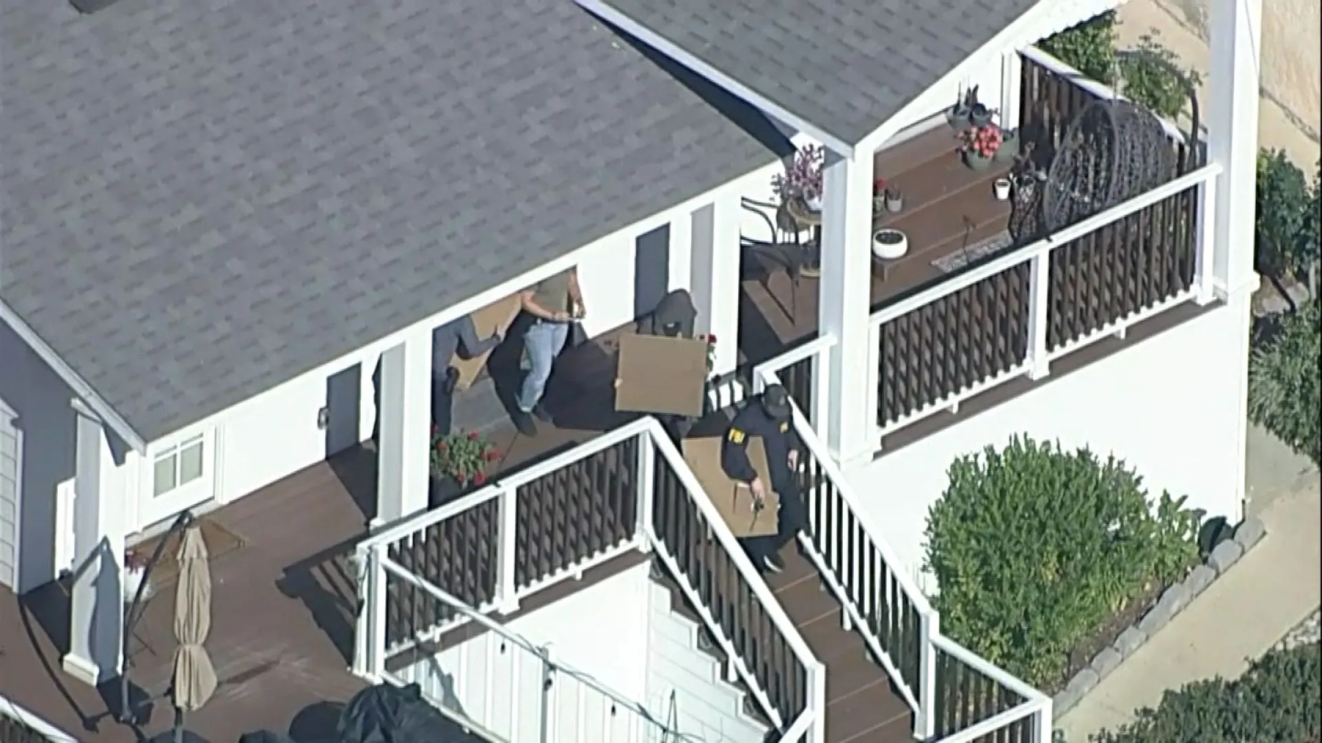 عملاء مكتب التحقيقات الفيدرالي يقومون بنقل صناديق من منزل مدير المدارس العامة في لوس أنجلوس خلال عملية تفتيش.