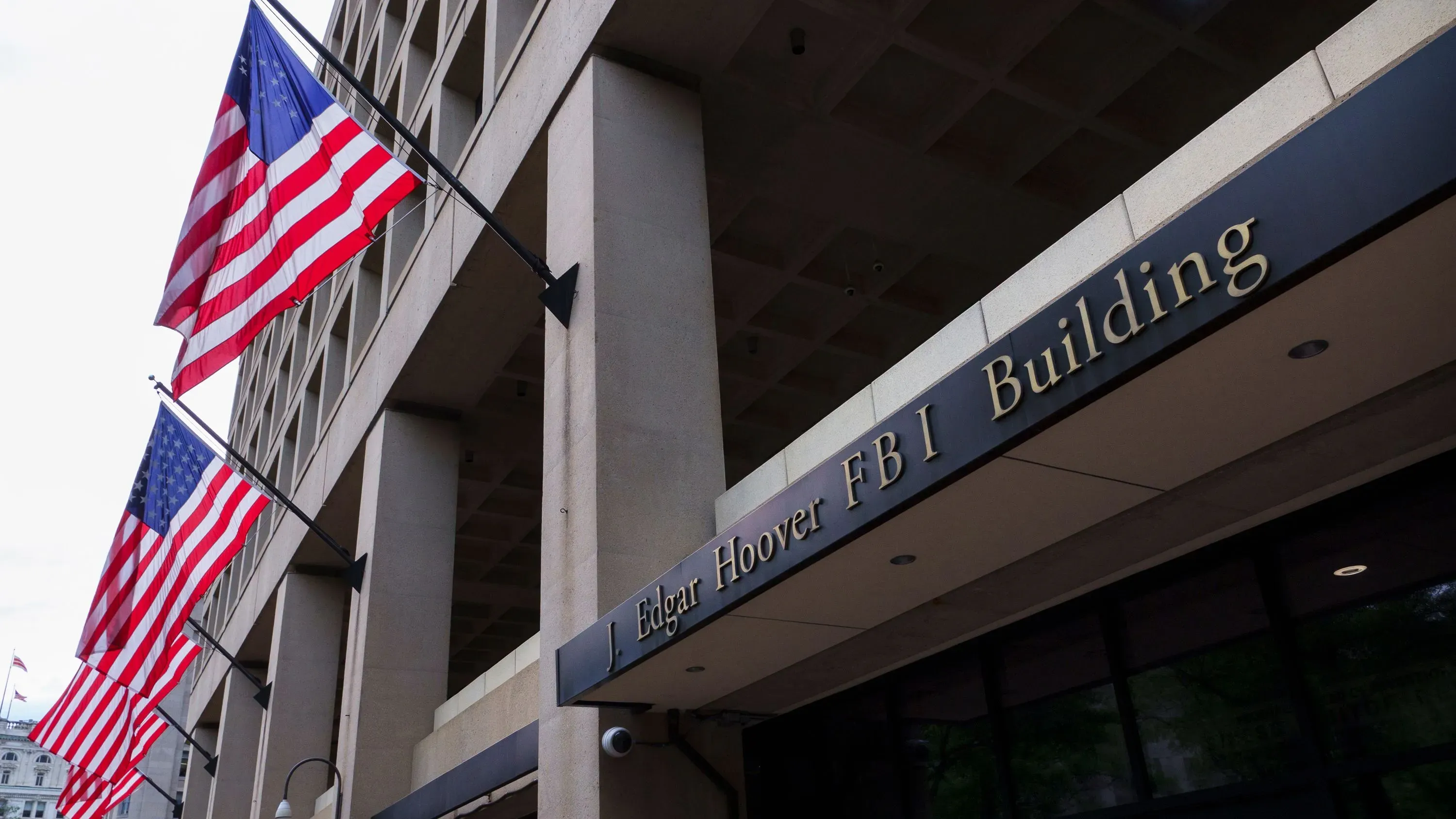 مبنى جيه إدغار هوفر لمكتب التحقيقات الفيدرالي، مع أعلام أمريكية ترفرف، يمثل نقطة تحول في خطط الانتقال إلى مبنى رونالد ريغان.