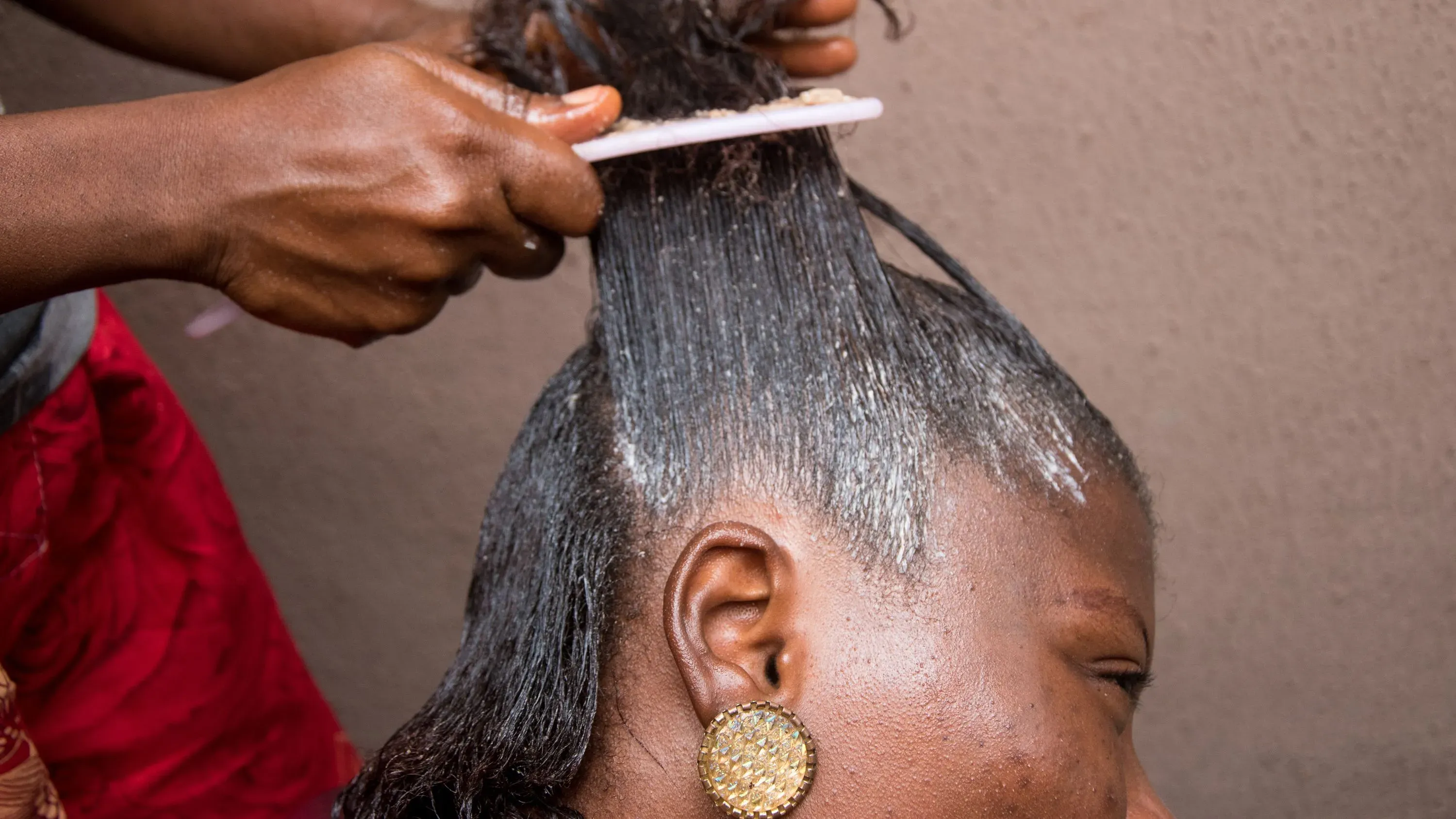 امرأة تتلقى علاج فرد الشعر في صالون، حيث يتم استخدام منتجات تحتوي على مواد كيميائية مثيرة للقلق مثل الفورمالديهايد.