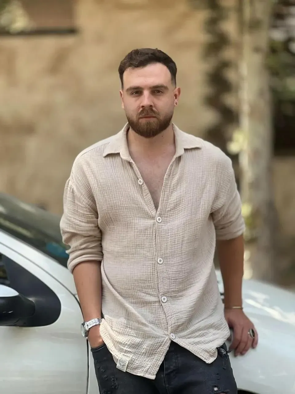 شاب إيراني يُدعى عرفان سلطاني، يقف بجوار سيارة، وسط مخاوف من إعدامه بسبب مشاركته في الاحتجاجات ضد الحكومة.