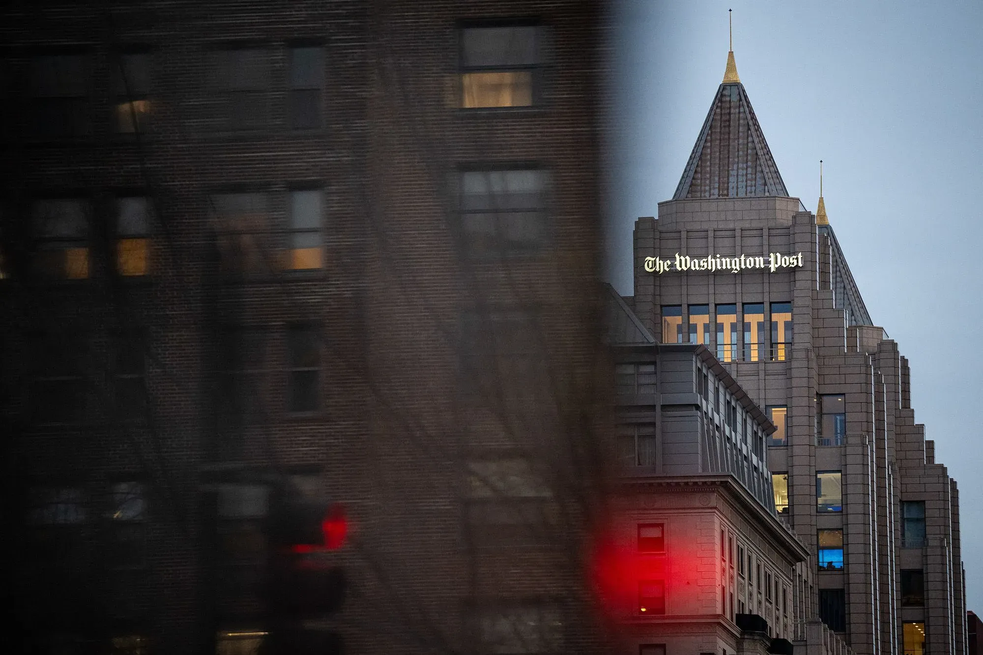 مبنى صحيفة واشنطن بوست يظهر في صورة ضبابية، مع إضاءة خافتة في النوافذ، مما يعكس الأجواء المحيطة بالقضية القانونية المتعلقة بمراسلتها.