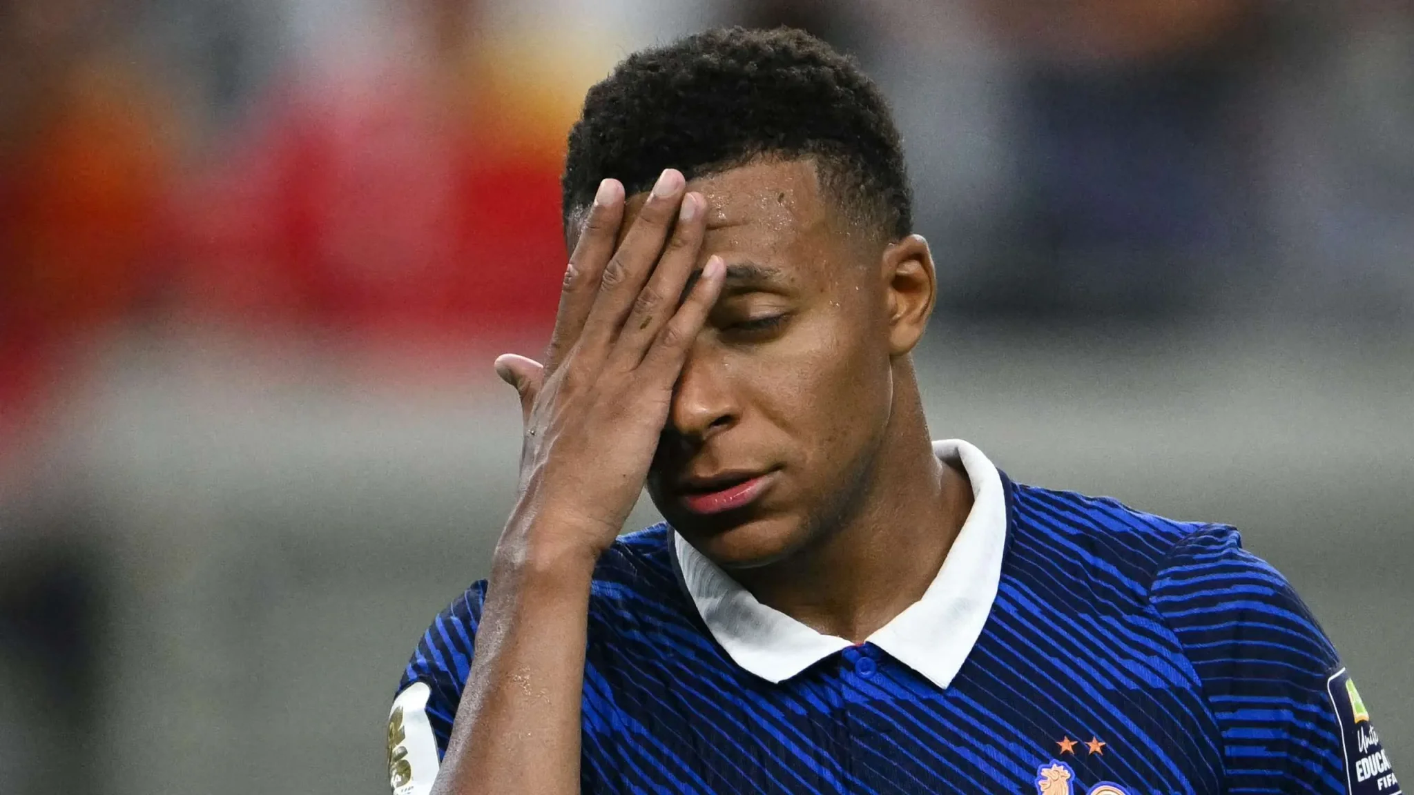 كيليان مبابي بزي منتخب فرنسا لكرة القدم، يضع يده على وجهه بتعبير يظهر الضغط أو الإحباط خلال بطولة كأس العالم 2026.
