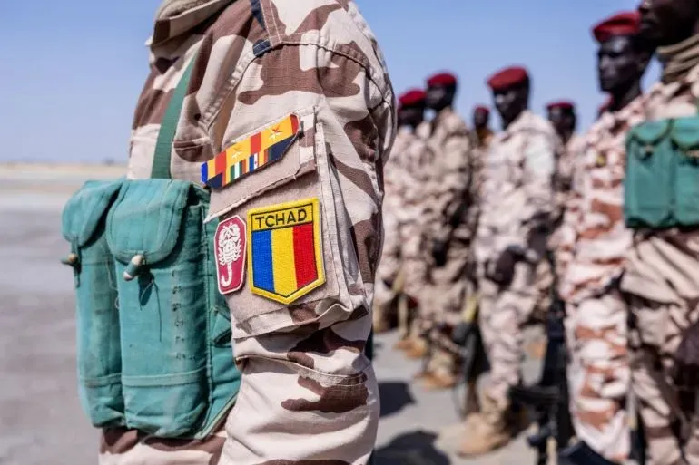 جنود تشاديون يرتدون زيًا عسكريًا، مع شارات تحمل رموز تشاد، أثناء استعدادهم لمواجهة تصاعد العنف في شرق البلاد.