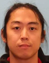 صورة لرجل ذو شعر أسود طويل، يبدو في الثلاثينيات من عمره، يظهر تعبيره الهادئ. تم توجيه الاتهام له بمحاولة قتل ضابط فيدرالي.