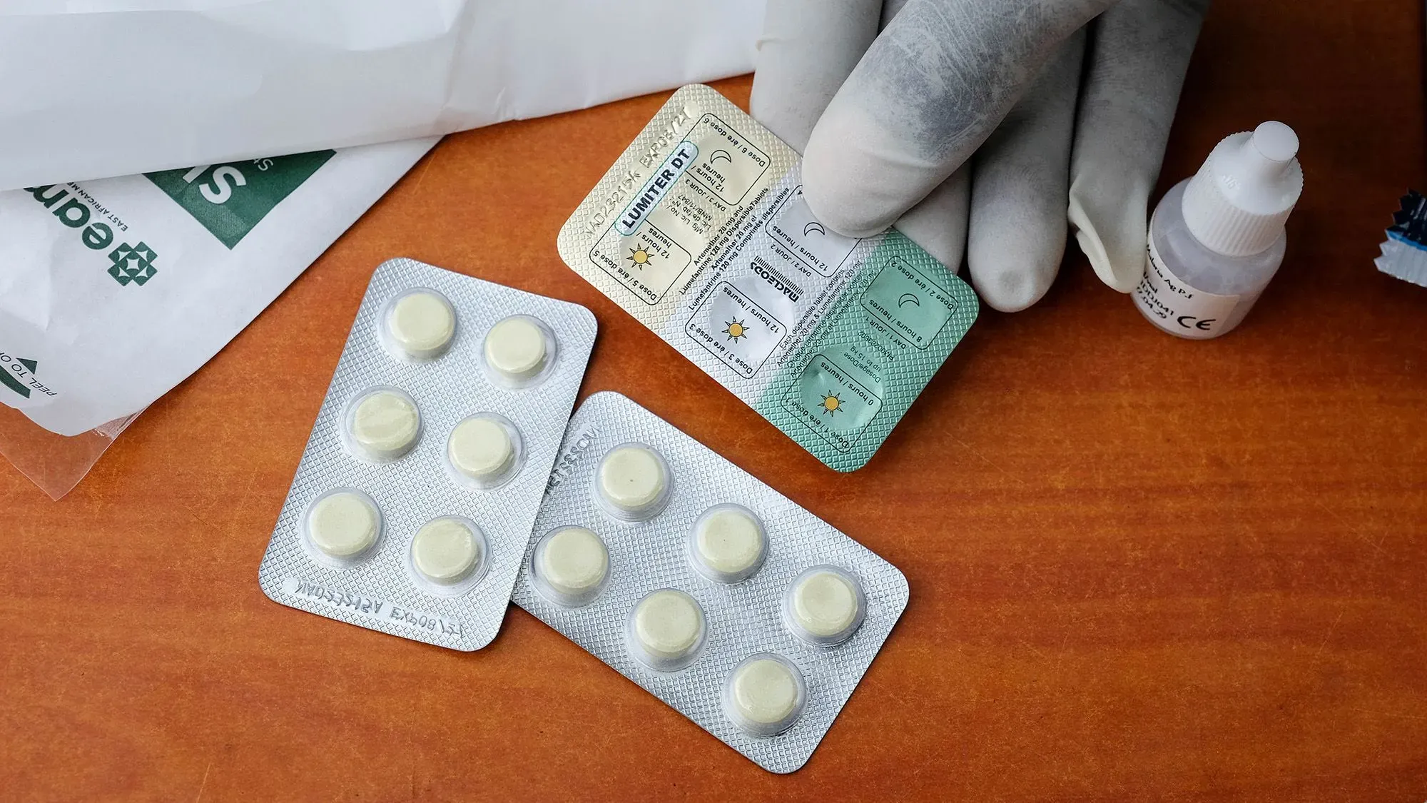 دواء Coartem Baby لعلاج الملاريا موضوعة على سطح خشبي، مع علبة دواء وقطارة، مما يعكس أهمية العلاج للأطفال حديثي الولادة.