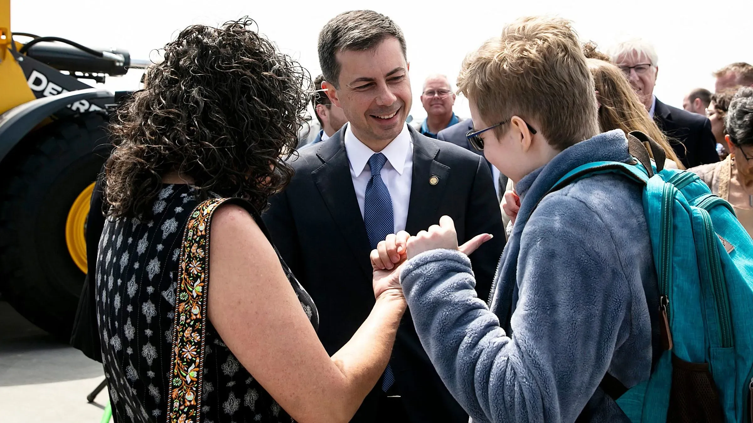 بوتيجيج يتفاعل مع مجموعة من الأشخاص خلال حدث في ولاية أيوا، حيث يركز على قضايا قدامى المحاربين وتأثير سياسات ترامب.