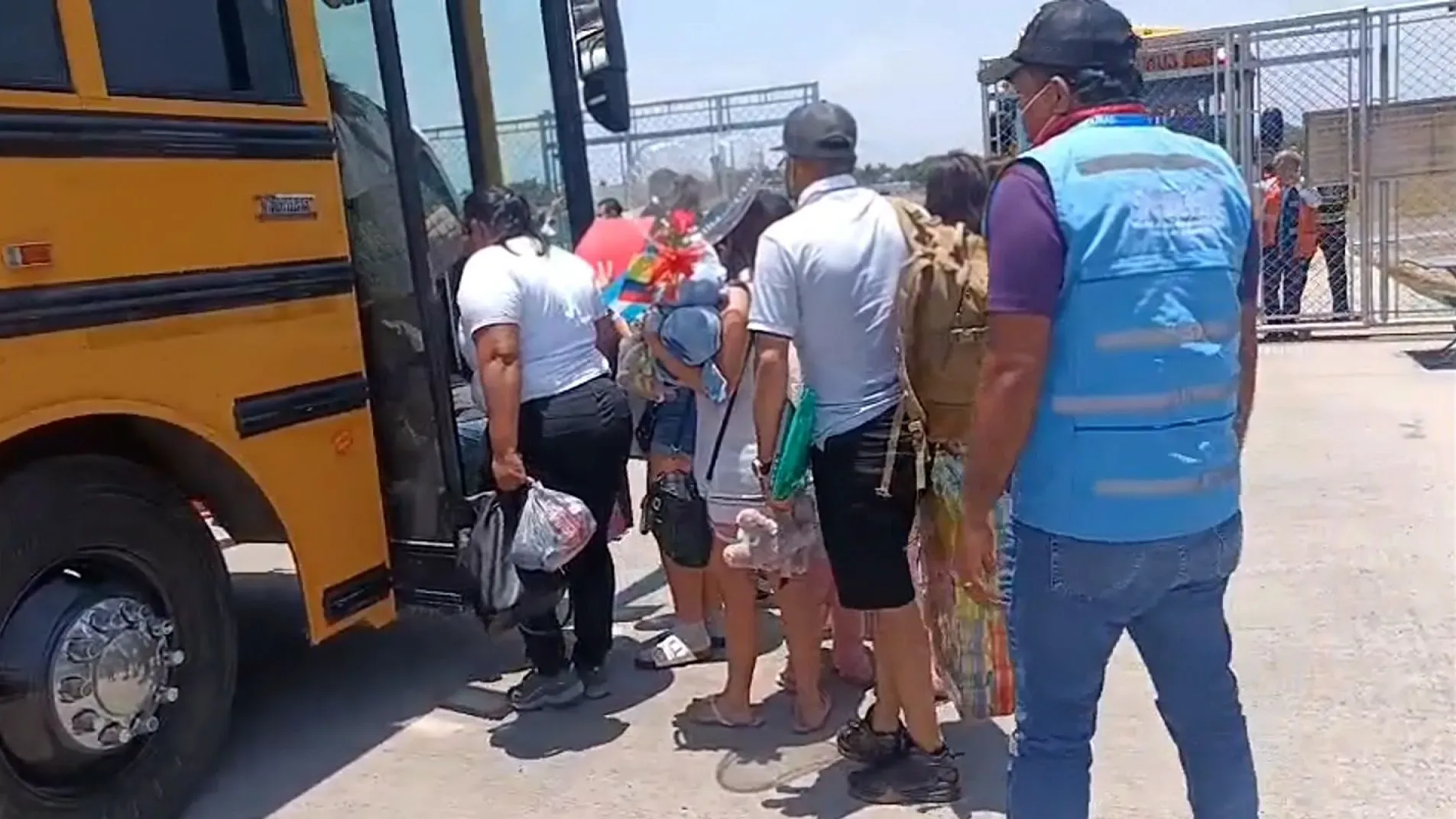 مجموعة من المهاجرين الهندوراسيين تستعد للصعود إلى حافلة صفراء بعد وصولهم إلى المطار، في إطار مبادرة الترحيل الذاتي من الولايات المتحدة.