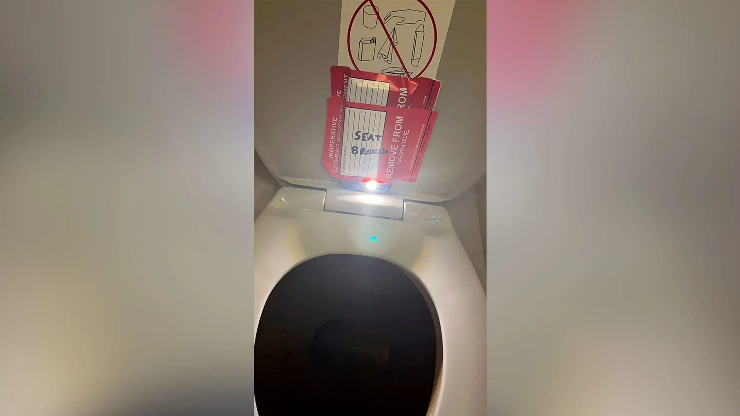 ملصقات حمراء على مقعد مرحاض الطائرة، تحمل تحذيرات عن عدم صلاحية الاستخدام، مع وجود هاتف مخفي لتسجيل الفيديو.