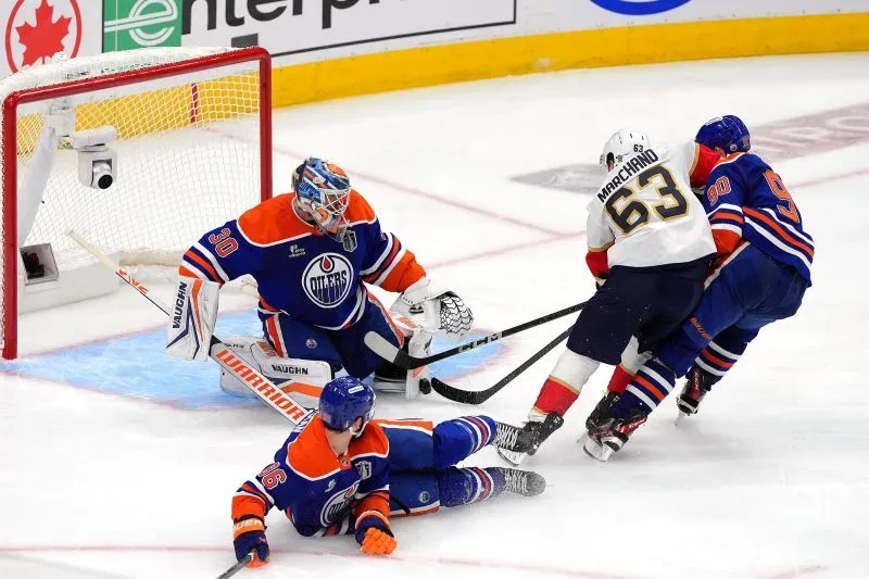 مارشان يسجل هدفًا لفريق فلوريدا بانثرز خلال مباراة كأس ستانلي ضد إدمونتون أويلرز، مع وجود حارس المرمى واللاعبين على الجليد.