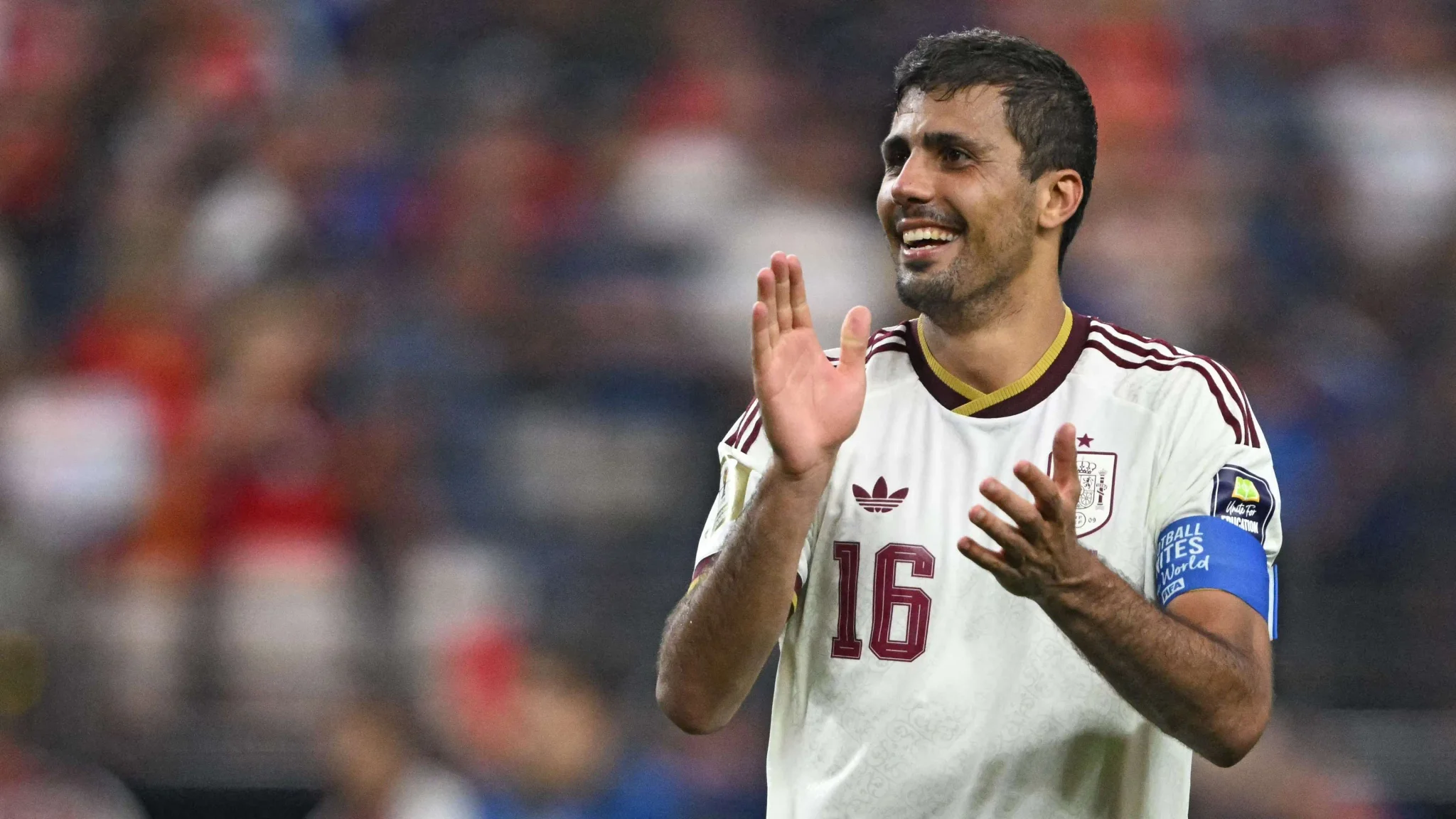 رودري قائد وسط منتخب إسبانيا يصفق مبتسمًا خلال مباراة كأس العالم، مع التركيز على دوره المحوري في تأهل إسبانيا للنهائي.