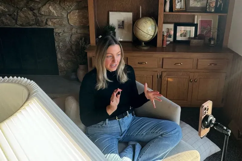 امرأة تتحدث بحماس أثناء جلوسها على أريكة، مع وجود كوكب وزخارف في الخلفية، تعبر عن أهمية الانتخابات وحقوق التصويت.