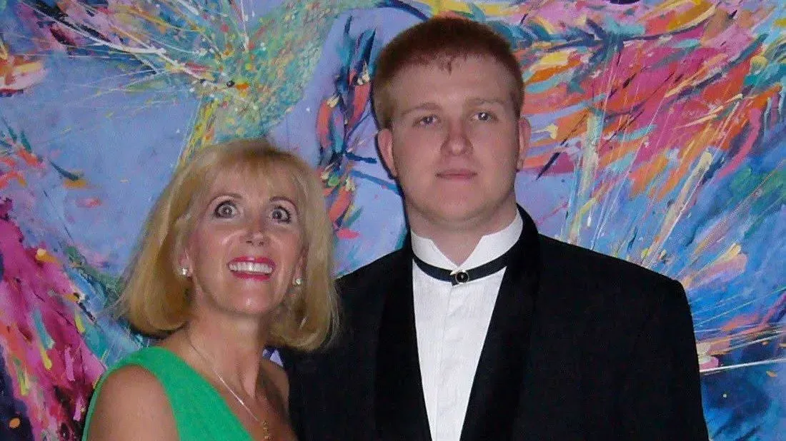 صورة لروري سايكس ووالدته، حيث يظهران مبتسمين في مناسبة خاصة، مع خلفية ملونة تعكس الفرح والأمل.