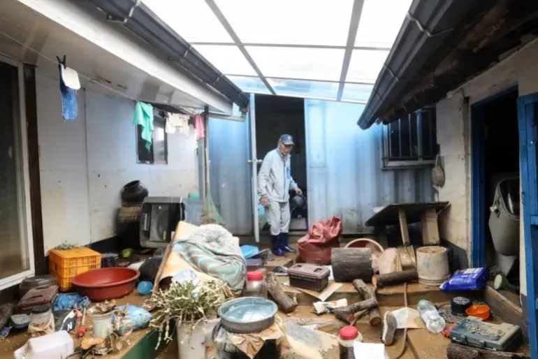 رجل يتفقد الأضرار داخل منزل غمرته مياه الفيضانات في كوريا الجنوبية، حيث تسببت الأمطار الغزيرة في إجلاء آلاف الأشخاص.