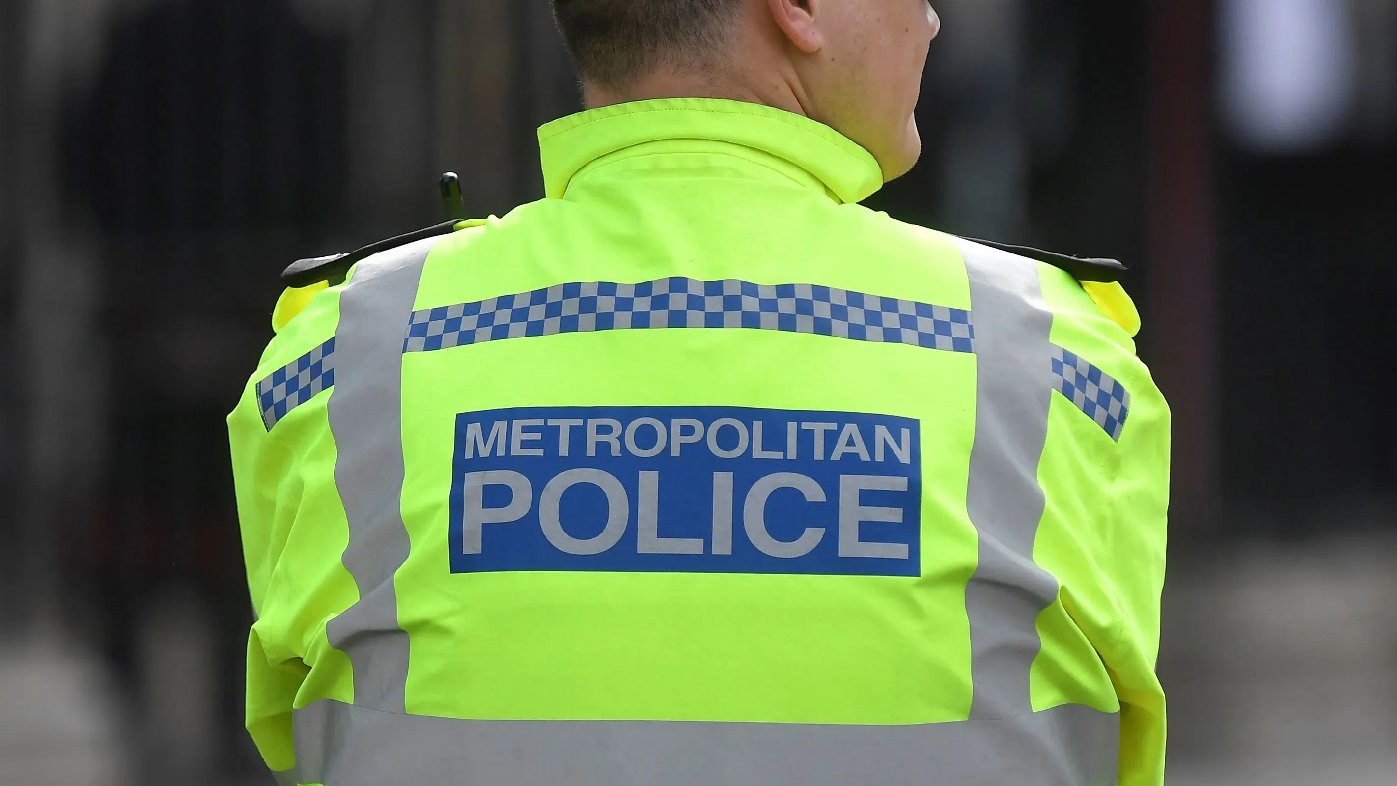 شرطي من شرطة العاصمة البريطانية يرتدي سترة عاكسة تحمل شعار "شرطة العاصمة"، في إطار التحقيقات المتعلقة بمخطط إرهابي.