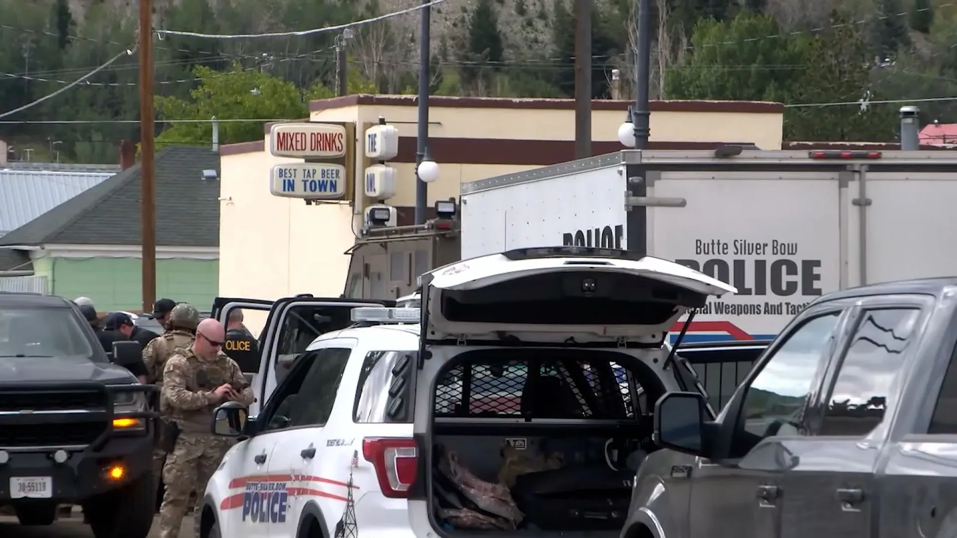 تحقيقات الشرطة في موقع حادث إطلاق نار في حانة في أناكوندا، مونتانا، مع وجود عناصر أمنية ومركبات شرطة.