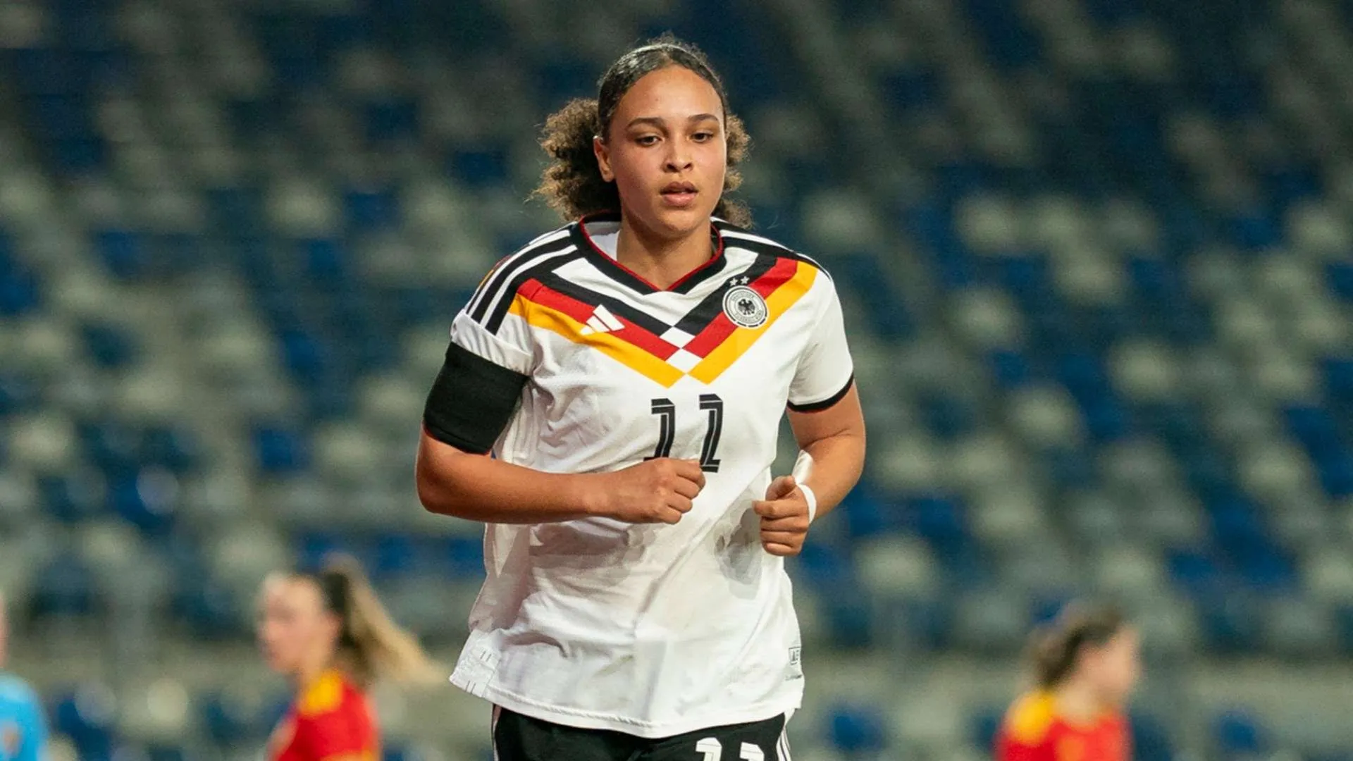 لاعبة كرة قدم نسائية ترتدي قميص منتخب ألمانيا رقم 11 في مباراة ضمن الدوري، تعبير عن انتقال أونا باتله إلى أرسنال في الدوري الإنجليزي للسيدات.