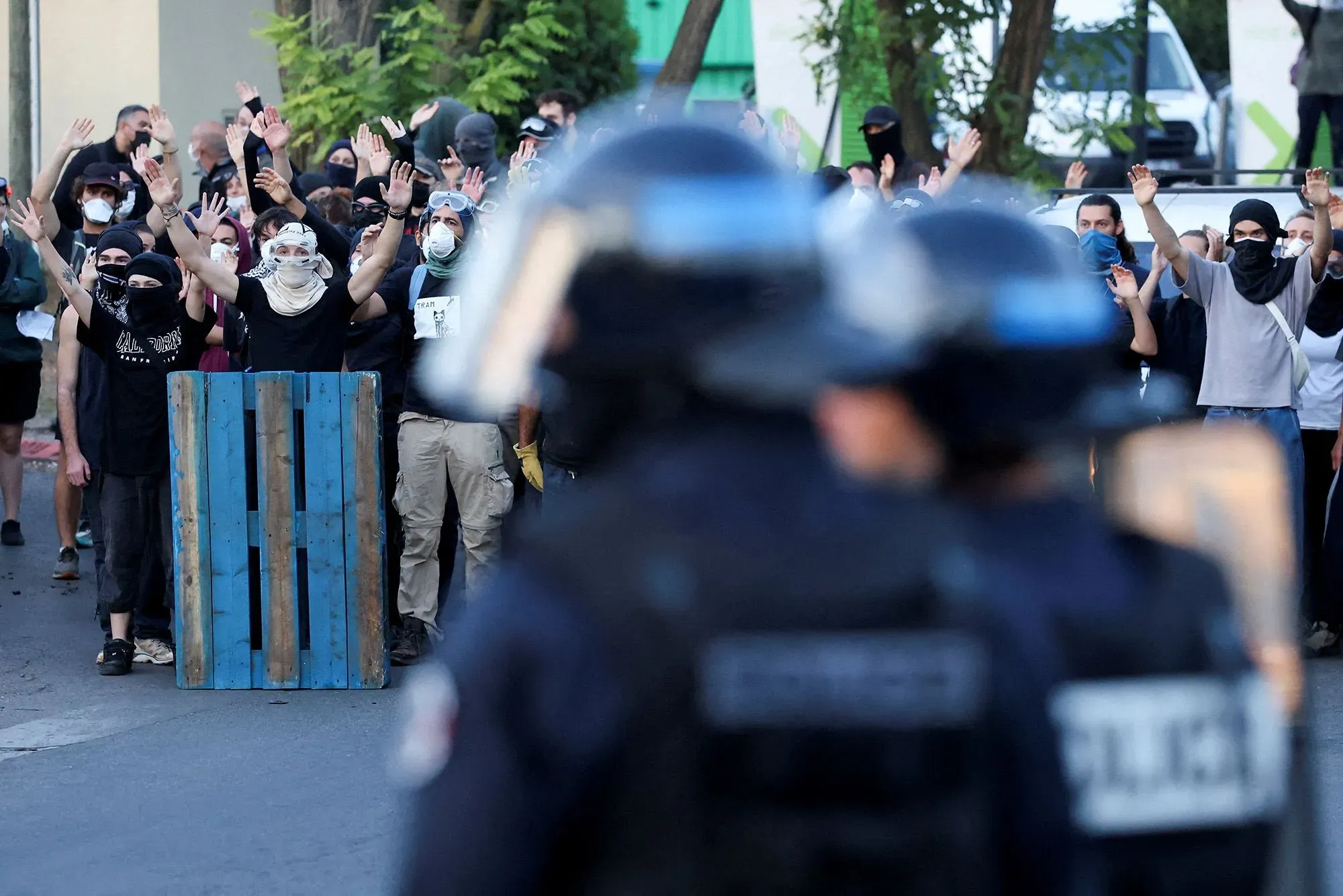 محتجون يرفعون أيديهم في مواجهة الشرطة خلال الاحتجاجات في فرنسا، مع تصاعد الغضب ضد الحكومة.