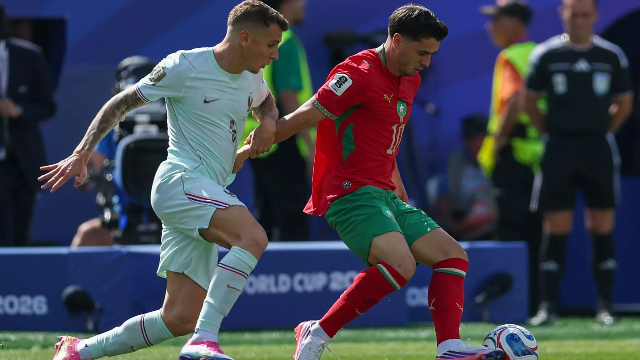 لاعب مغربي يحاول السيطرة على الكرة تحت ضغط مدافع فرنسي خلال مباراة كأس العالم بين المغرب وفرنسا.