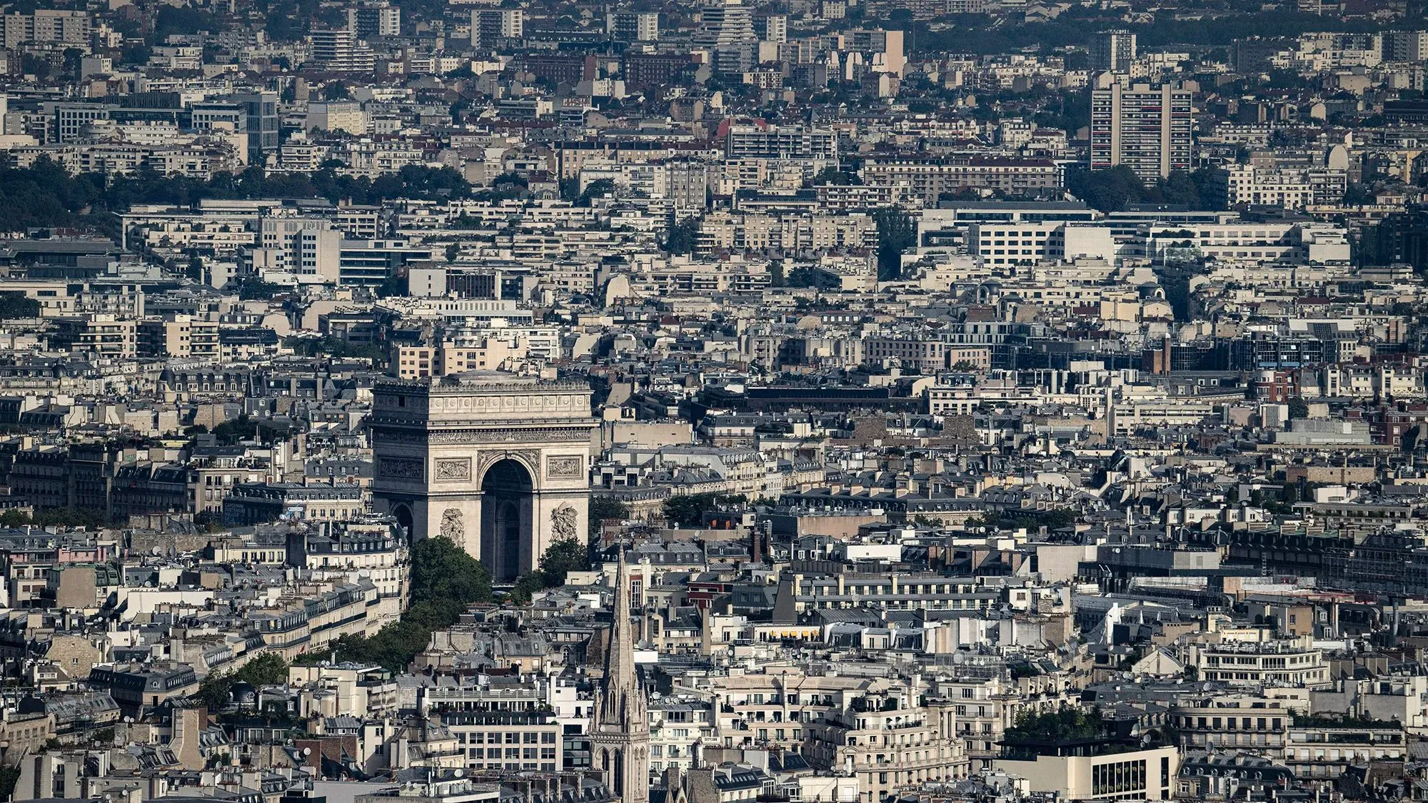 منظر جوي لمدينة باريس يظهر قوس النصر وسط المباني، يعكس الاستعدادات الفرنسية لمواجهة التهديدات الأمنية والطبيعية.