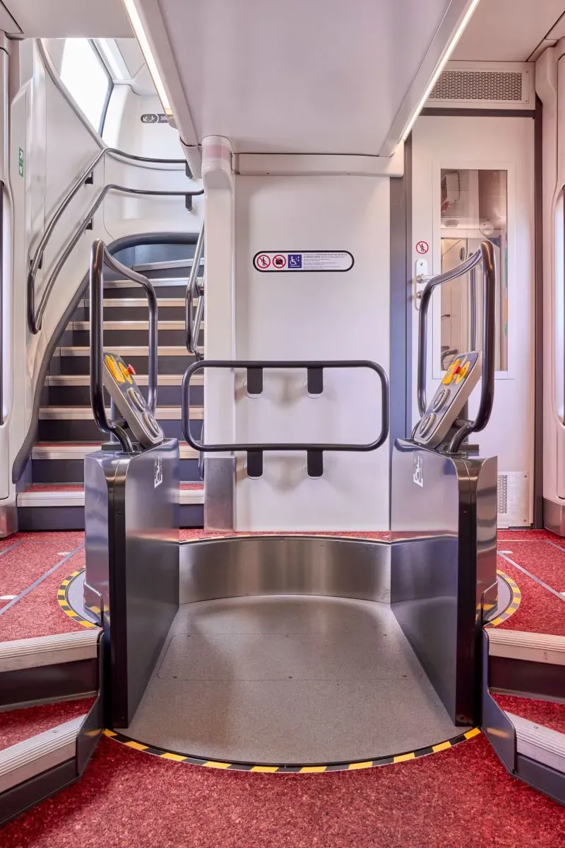 تصميم داخلي حديث لقطار INOUUI الجديد، يظهر سلالم وممرات واسعة مع إمكانية الوصول لذوي الاحتياجات الخاصة، يعكس الراحة والابتكار في السفر.