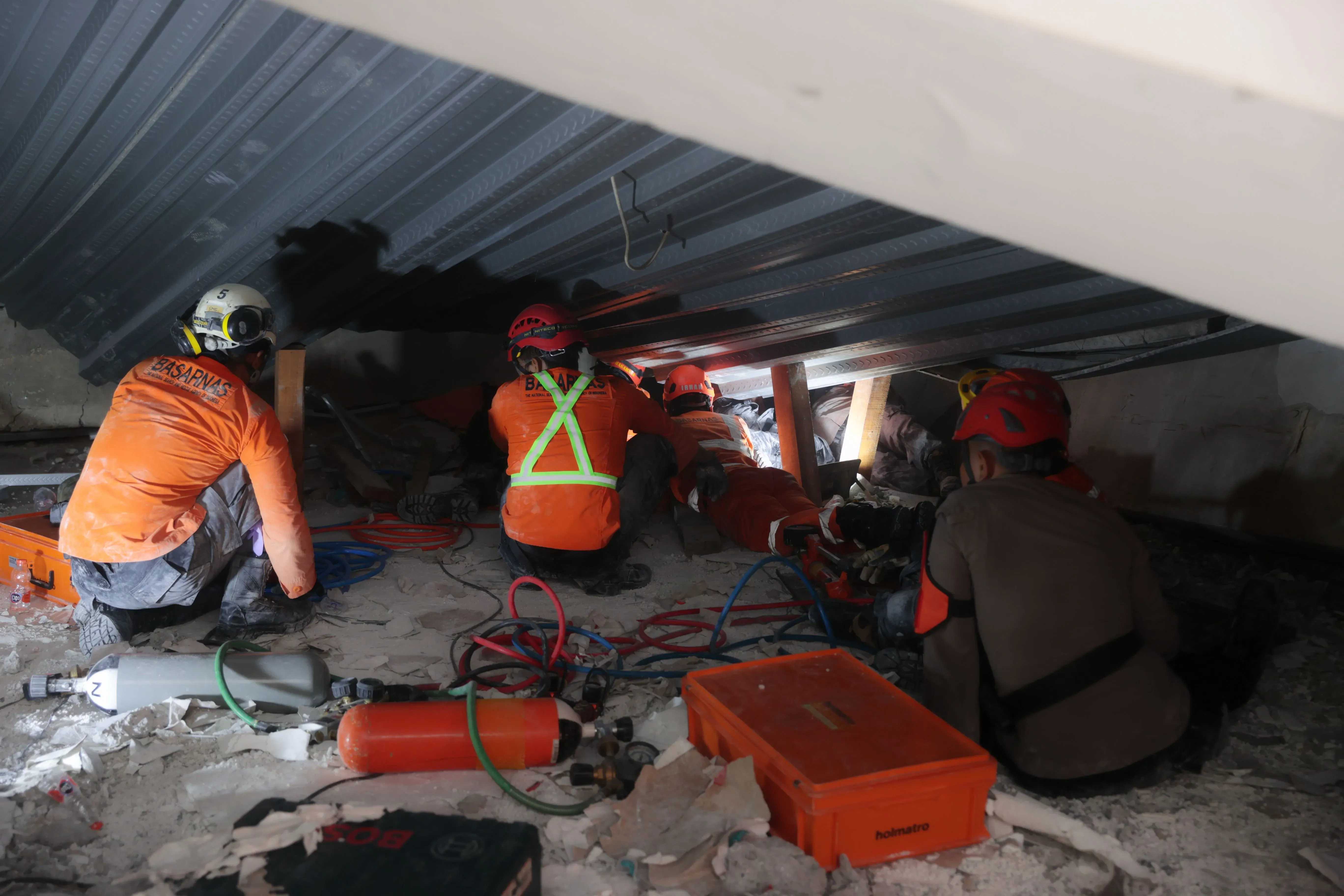 فرق الإنقاذ الإندونيسية تعمل تحت الأنقاض في مدرسة منهارة، حيث يحاولون إنقاذ الطلاب المحاصرين وتقديم الأكسجين لهم.