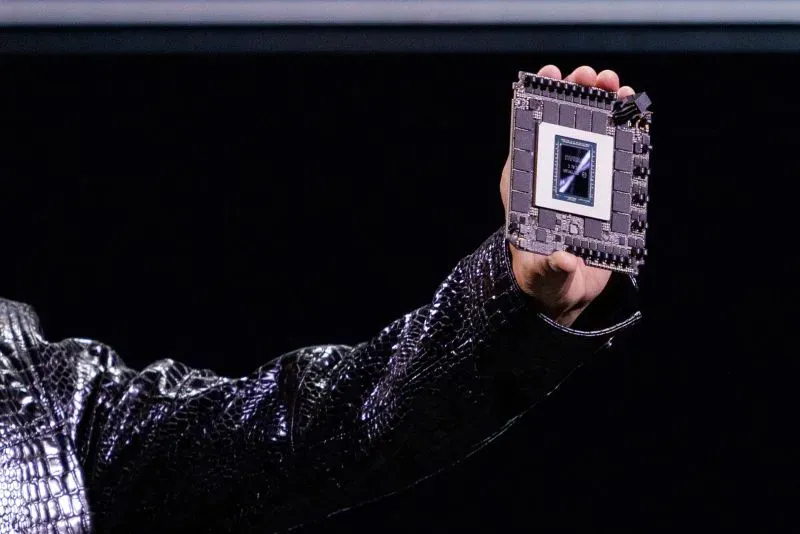 شخص يحمل شريحة رسومات GeForce RTX 5090 الجديدة، التي تعد محط اهتمام كبير للاعبين، وسط حديث عن تأثير الحرب التكنولوجية بين الولايات المتحدة والصين.