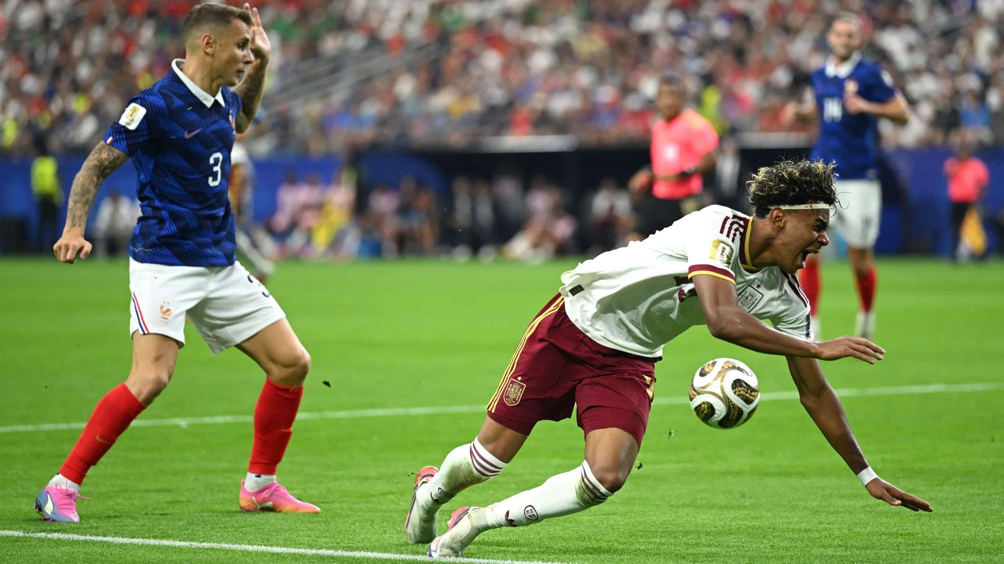 لاعب يامال من إسبانيا يسقط أثناء مواجهة لاعب فرنسي في مباراة كأس العالم 2026، مع التركيز على الأداء الشاب في كرة القدم.