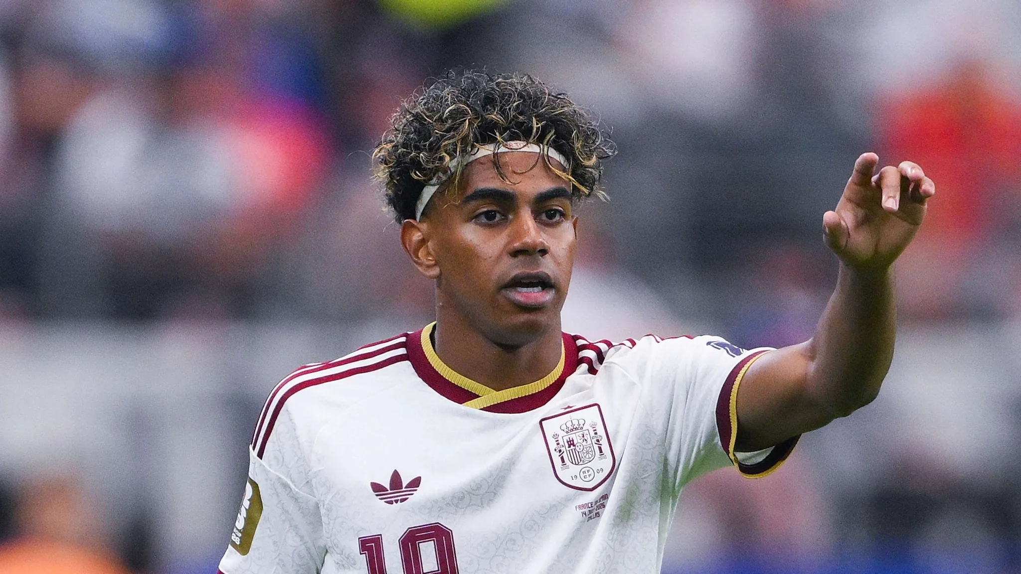 يامل لاعب منتخب إسبانيا الشاب يرتدي قميص المنتخب الأبيض ويشير بيده خلال مباراة كأس العالم 2026، مع تركيز على أدائه ودوره في الفريق.