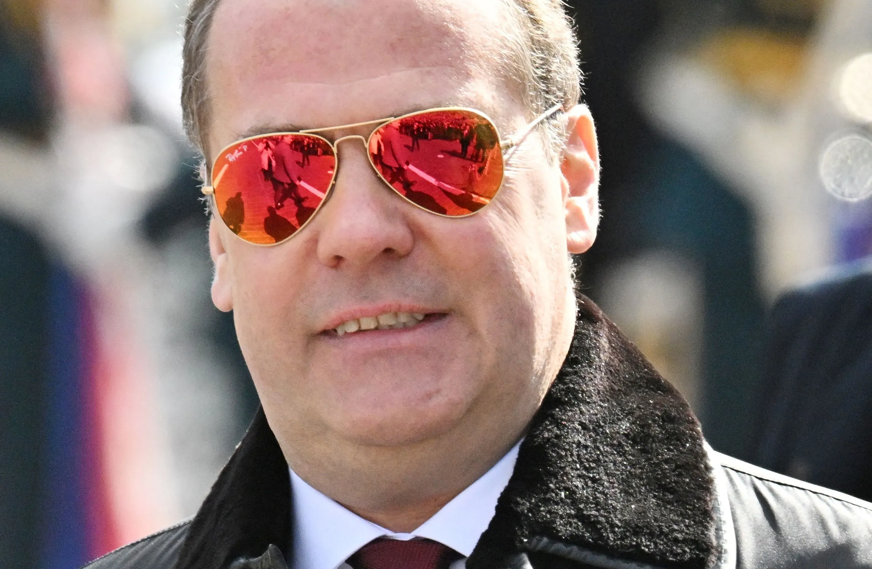 ديمتري ميدفيديف يرتدي نظارات شمسية عاكسة، مبتسمًا في مناسبة عامة، مما يعكس تحول شخصيته السياسية من ليبرالي إلى قومي متطرف.