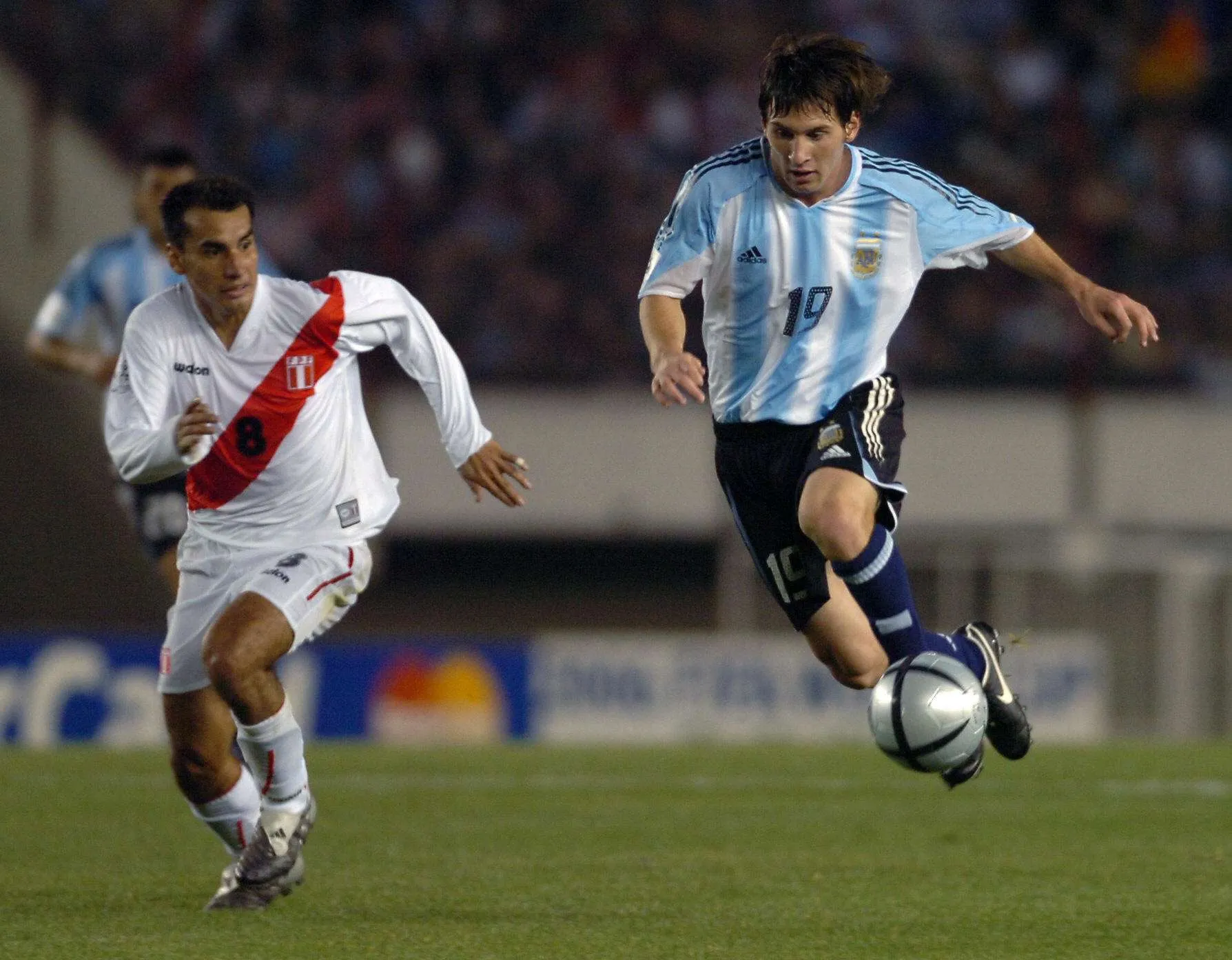 ليونيل ميسي الشاب يركض بالكرة خلال مباراته الأولى مع منتخب الأرجنتين عام 2005 ضد بيرو، بداية مسيرة دولية أسطورية.