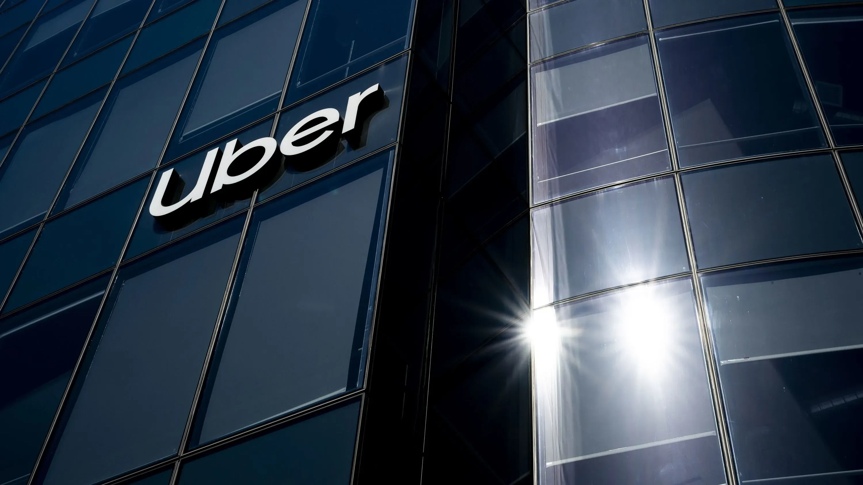 واجهة مبنى شركة أوبر مع شعار الشركة، تعكس القضايا القانونية المتعلقة بممارسات الفوترة والإلغاء في خدمة Uber One.