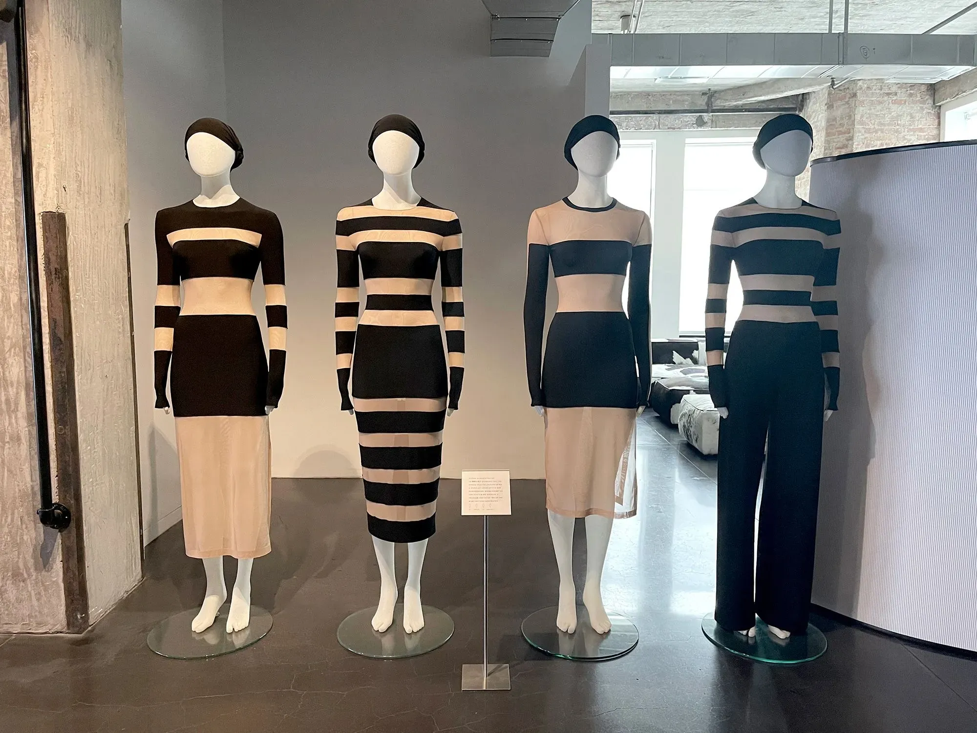 عرض لفساتين مصممة بتقنية الذكاء الاصطناعي، تتضمن أنماطاً متداخلة بالألوان الأسود والبيج، تعكس الابتكار في عالم الموضة.