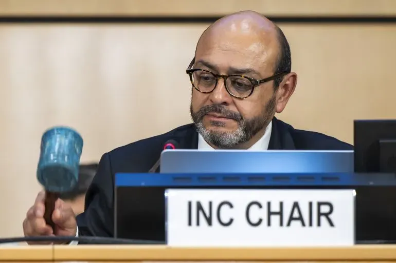 رئيس لجنة التفاوض يحمل مطرقة مصنوعة من أغطية زجاجات بلاستيكية، مع تعبيرات وجه تعكس الإحباط بعد فشل المحادثات بشأن معاهدة التلوث البلاستيكي.