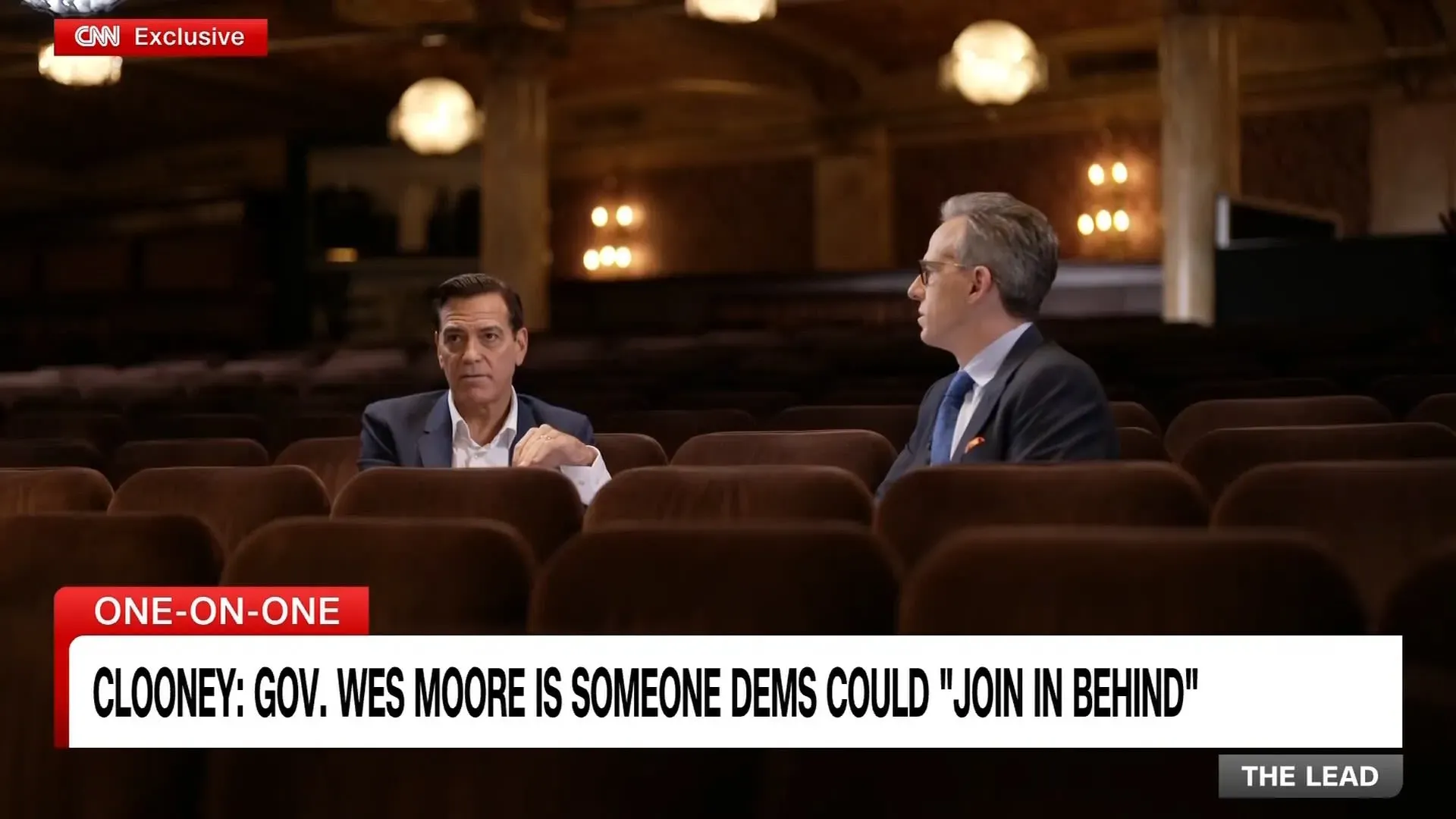 جورج كلوني يتحدث مع باتي لوبون في مسرح، حيث يناقشان القضايا السياسية والتفاؤل بمستقبل الولايات المتحدة.