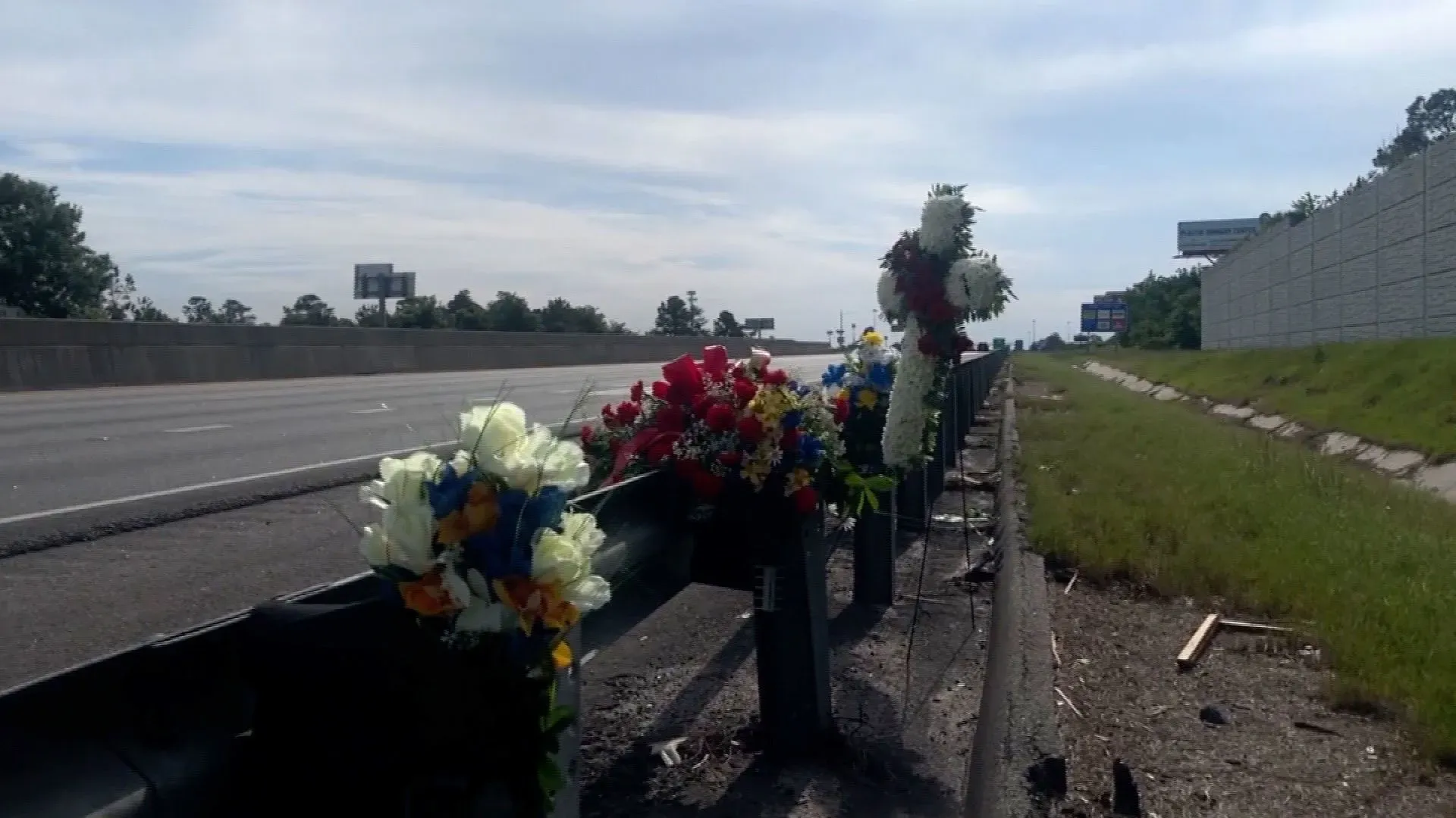 تظهر الصورة زهورًا اصطناعية ملونة مثبتة على سياج على جانب الطريق السريع، تكريمًا لذكرى النائب براندون سايكس الذي قُتل في حادث إطلاق نار.